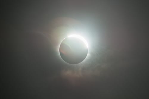 A solar eclipse occurs when the Moon passes between Earth and the Sun, thereby totally or partly obscuring the image of the Sun for a viewer on Earth. A total solar eclipse occurs when the Moon's apparent diameter is larger than the Sun's, blocking all direct sunlight, turning day into darkness. Totality occurs in a narrow path across Earth's surface, with a partial solar eclipse visible over a surrounding region thousands of kilometres wide.
