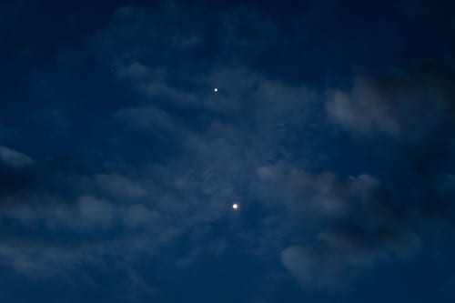 CHONGQING, CHINA - AUGUST 14: Jupiter (top) and Venus (bottom) are seen shining brightly in the eastern sky before sunrise on August 14, 2025, in Chongqing, China. The two planets appeared close together in a celestial event visible to the naked eye, with scattered clouds adding depth to the early morning scene. (Photo by Cheng Xin/Getty Images)