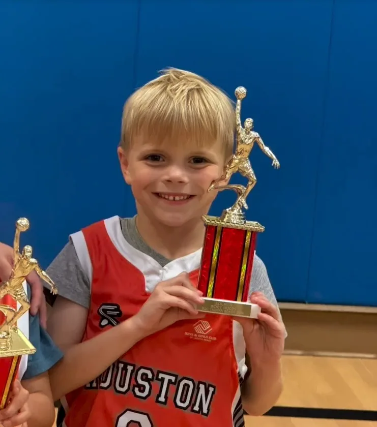 Hudson looks all grown up as he proudly holds a trophy