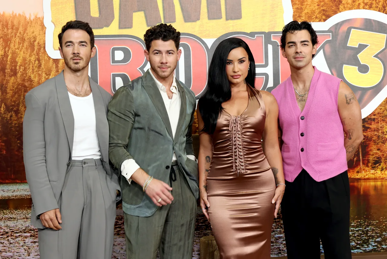 The Jonas Brothers compliments Demi Lovato's glamorous style in Giorgio Armani looks