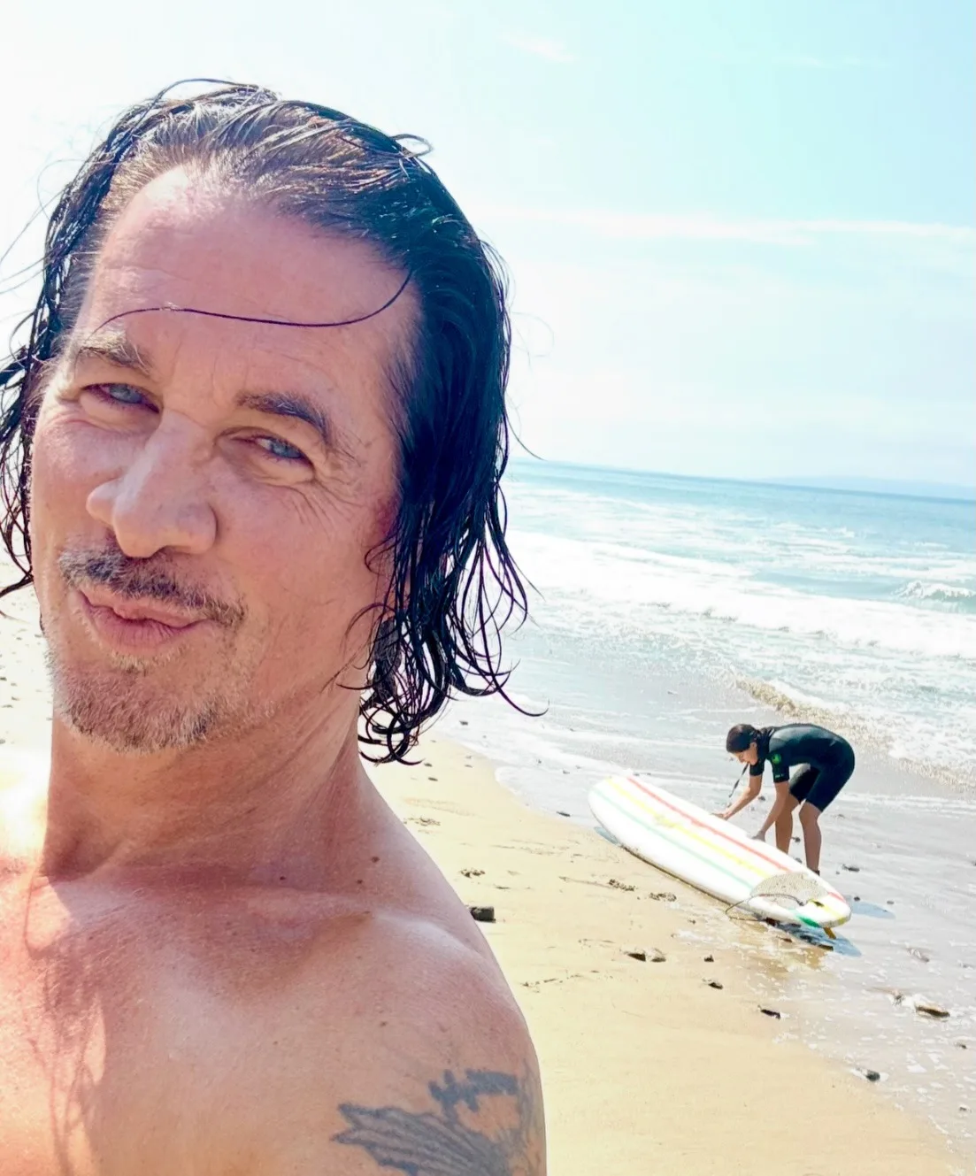 Michael Easton proudly shows off daughter Lilah's surfing skills
