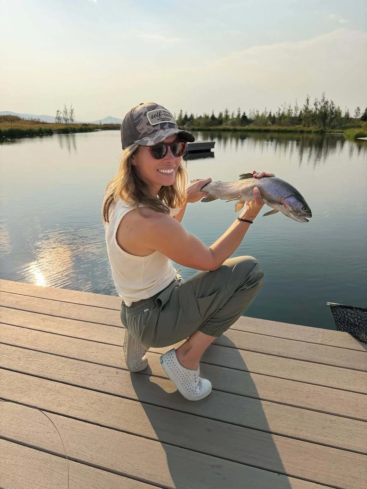 Jessica Biel smiles for the camera while holding a freshly-caught fish