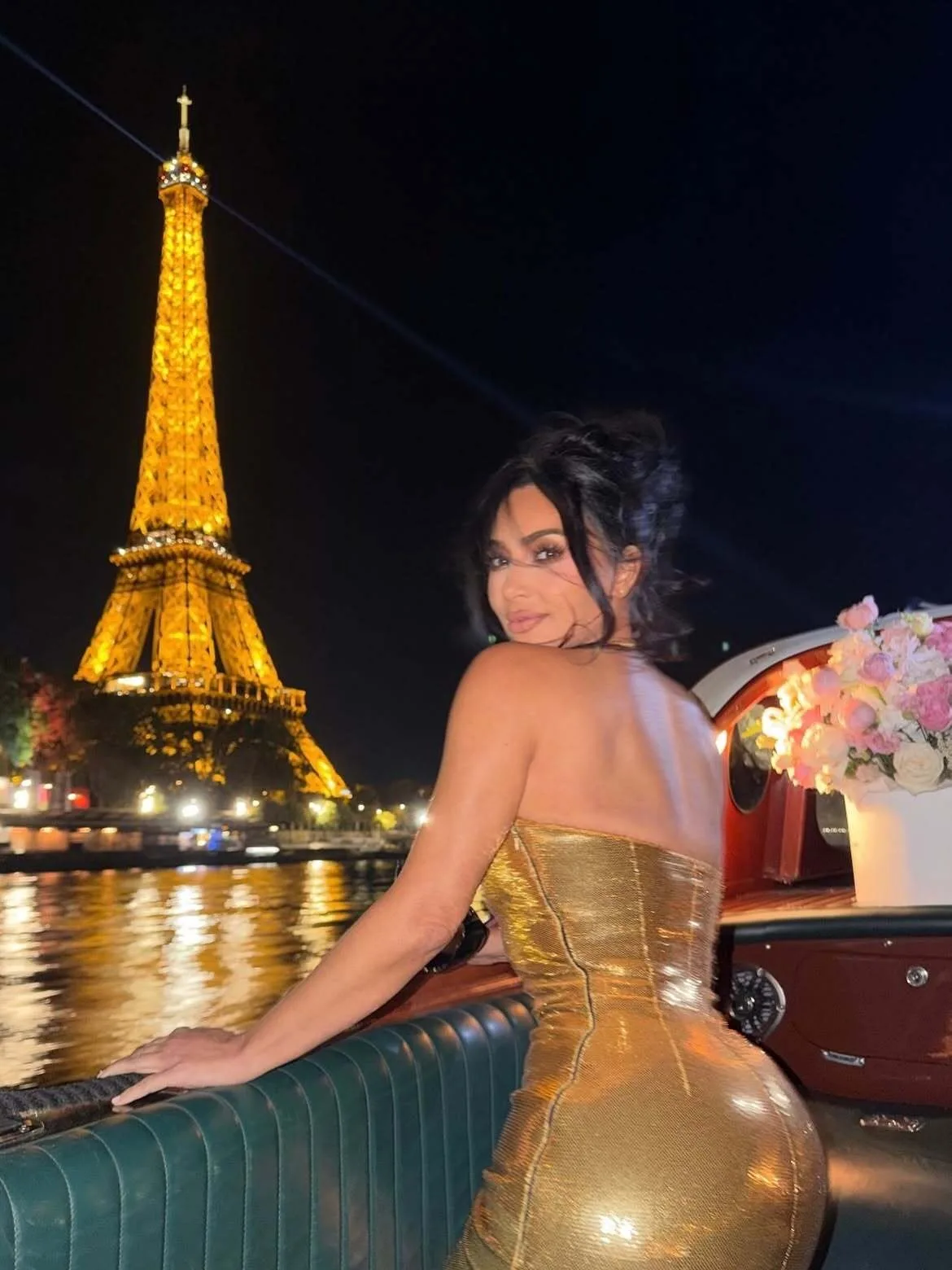 Kim Kardashian glows in front of the Eiffel Tower’s shimmering lights