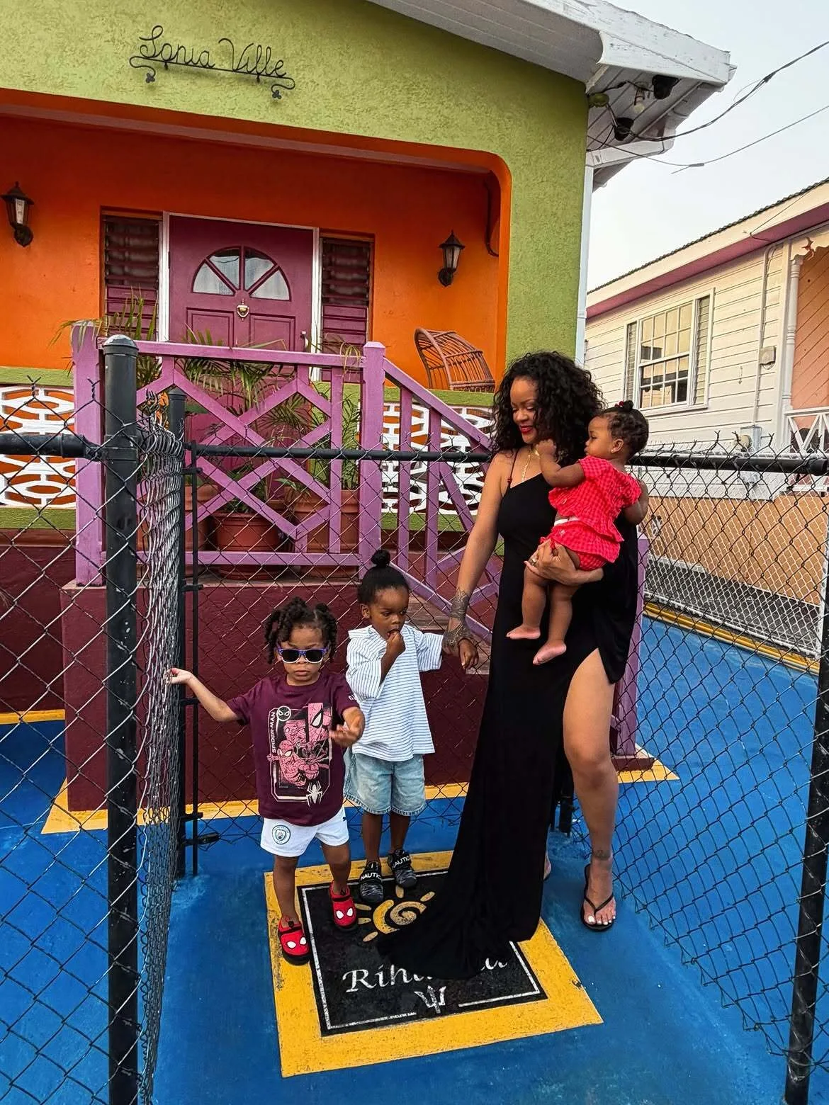 Rihanna stuns in black one-shoulder dress while posing with her kids