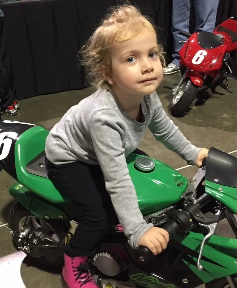 Hattie poses on a toy bike in throwback picture
