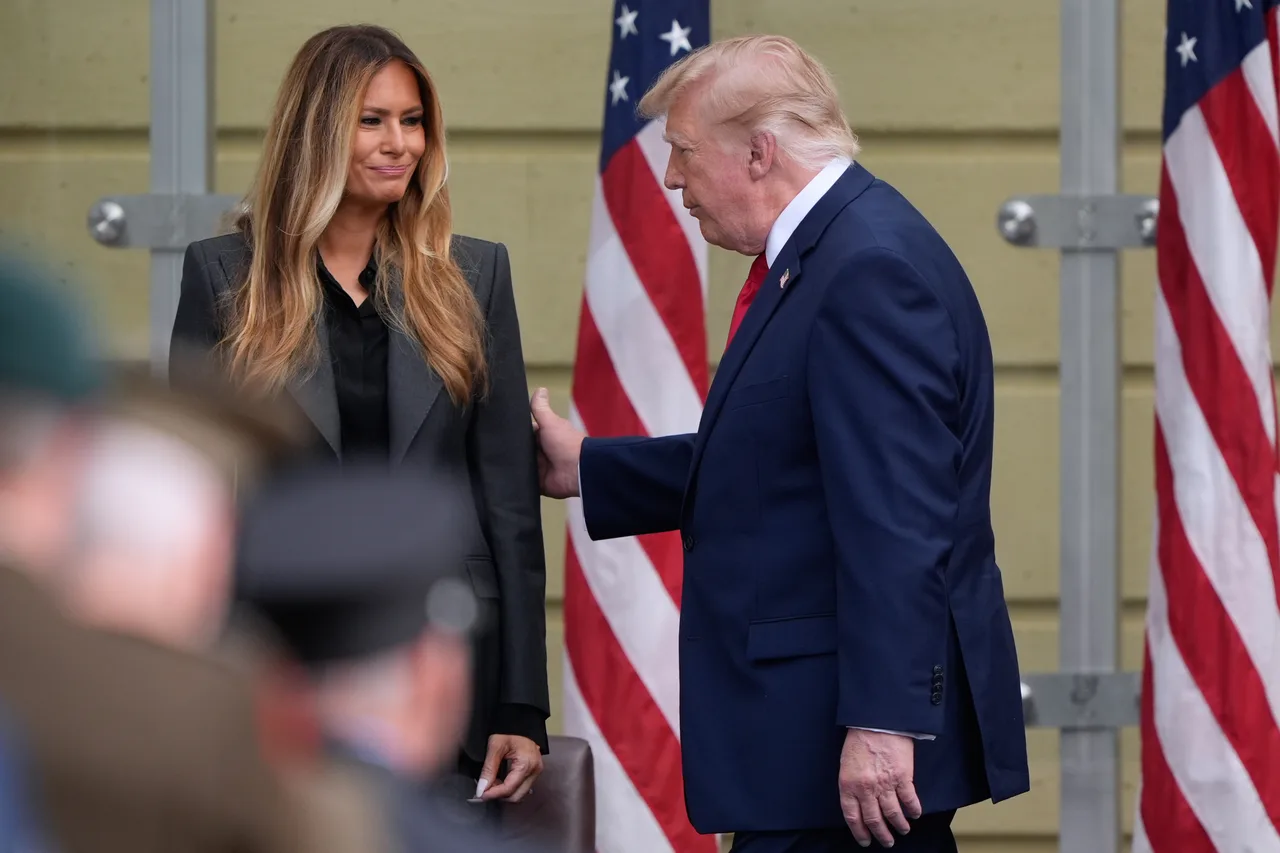 Melania smiles as Trump reaches toward her