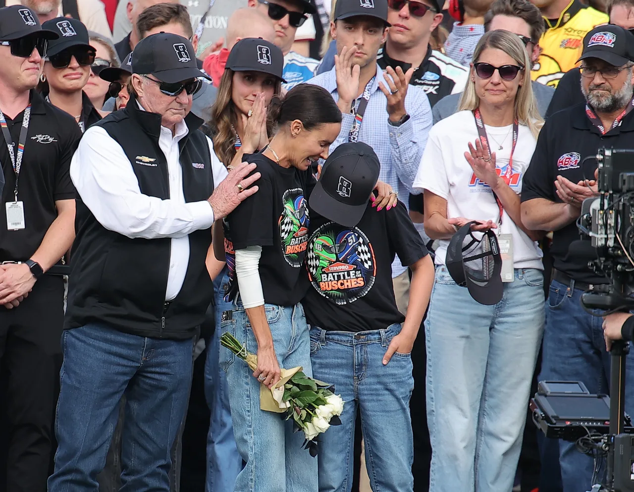Samantha Busch walks onto the track with white flowers