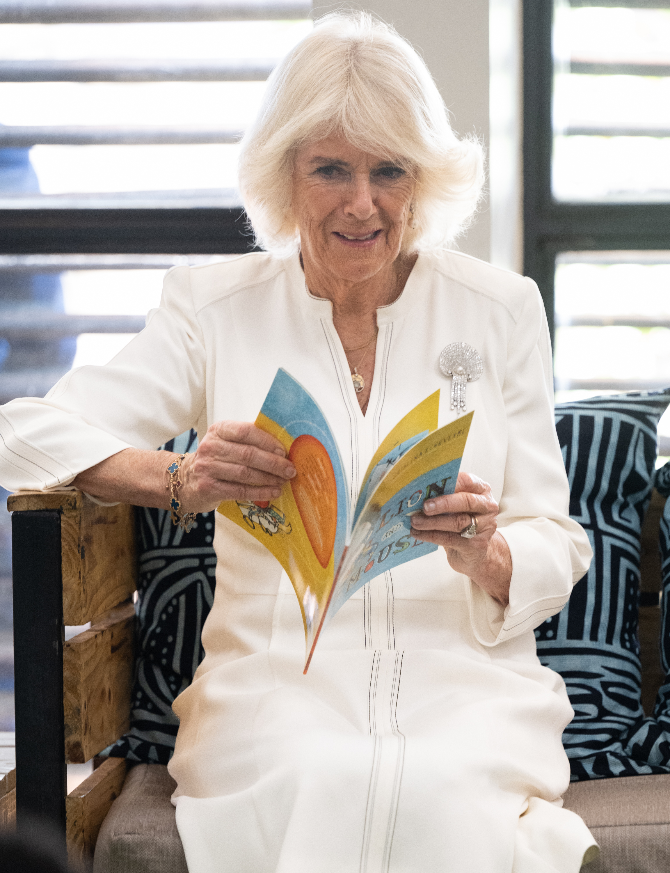 NAIROBI, KENYA - OCTOBER 31: Queen Camilla reads Lion and Mouse with children during her visit to Eastlands Library, with King Charles III, where she met the founders of Book Bunk, a Kenyan charity that restores public libraries and the King will join young people taking part in a Prince’s Trust International (PTI) Enterprise Challenge on on October 31, 2023 in Nairobi, Kenya. King Charles III and Queen Camilla are visiting Kenya for four days at the invitation of Kenyan President William Ruto, to celebrate the relationship between the two countries. The visit comes as Kenya prepares to commemorate 60 years of independence. (Photo by Samir Hussein/WireImage)