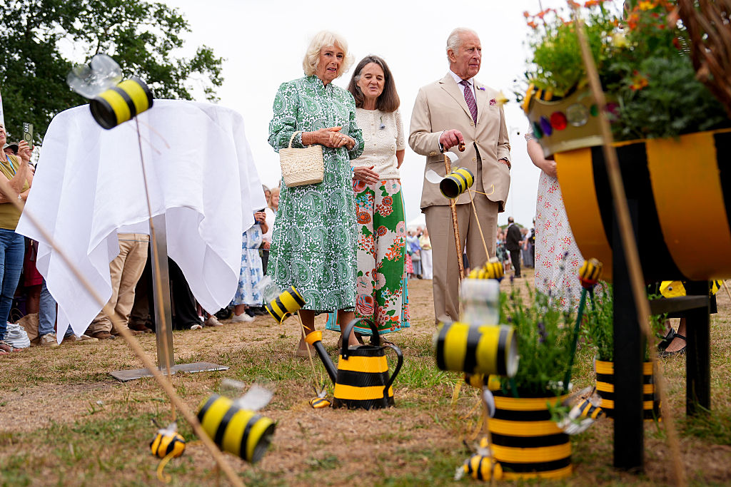 SANDRINGHAM, NORFOLK - JULY 22: King Charles III, Patron of the Royal Horticultural Society (RHS) and Queen Camilla view the Queen Bee garden, designed by Ingoldisthorpe Church of England Primary School, during a visit to the RHS Sandringham Flower Show, which is being held for the first time this year on the Sandringham Estate on July 22, 2026 in Sandringham, Norfolk. The event was the first Royal Horticultural Society (RHS) show to be held at Sandringham Estate. (Photo by Aaron Chown - WPA Pool/Getty Images)