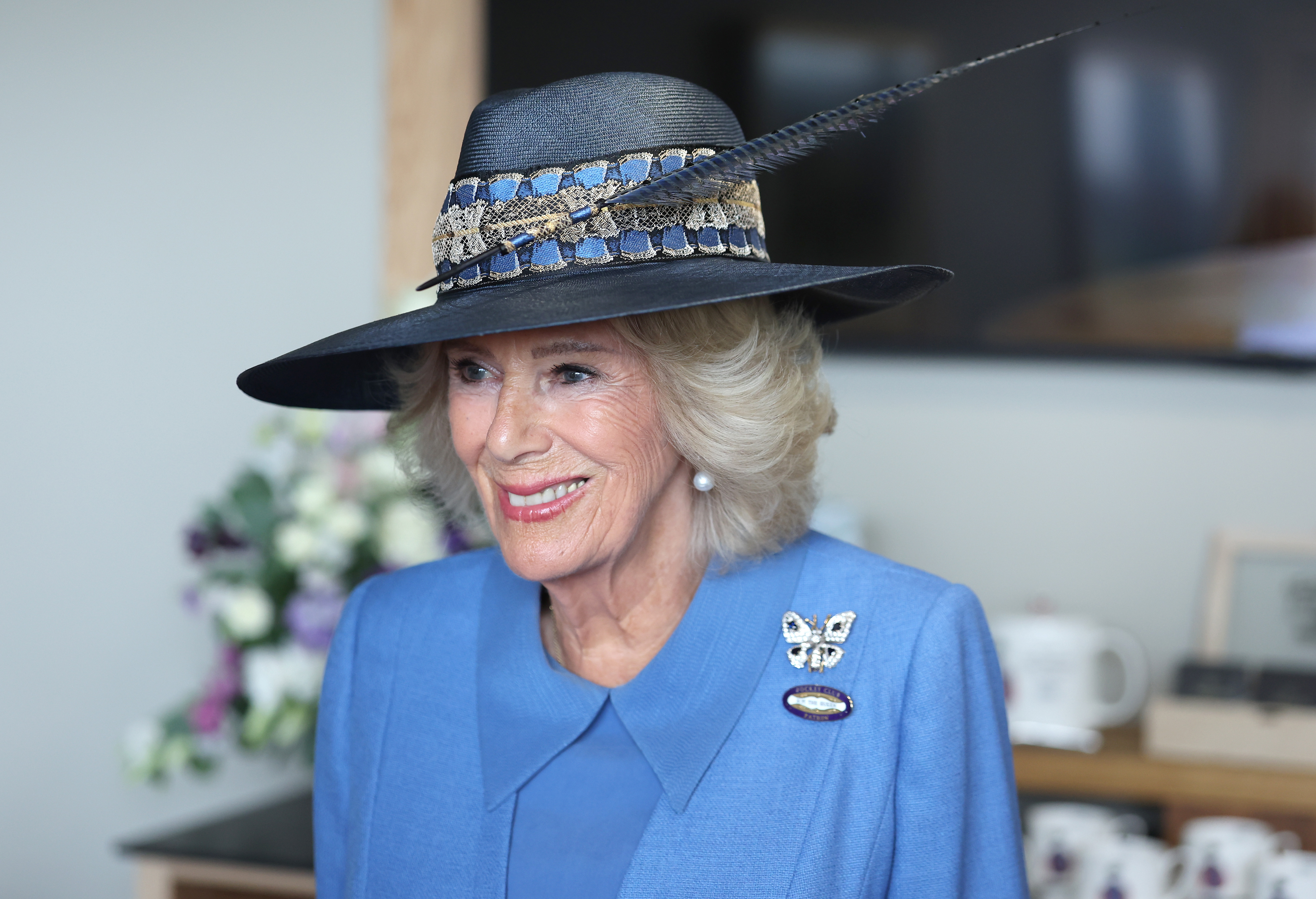 YORK, ENGLAND - AUGUST 19: Queen Camilla, Patron of York Racecourse, smiles as she speaks to staff members during the first day of the Ebor Festival at York Racecourse on August 19, 2026 in York, England. (Photo by Chris Jackson/Getty Images)