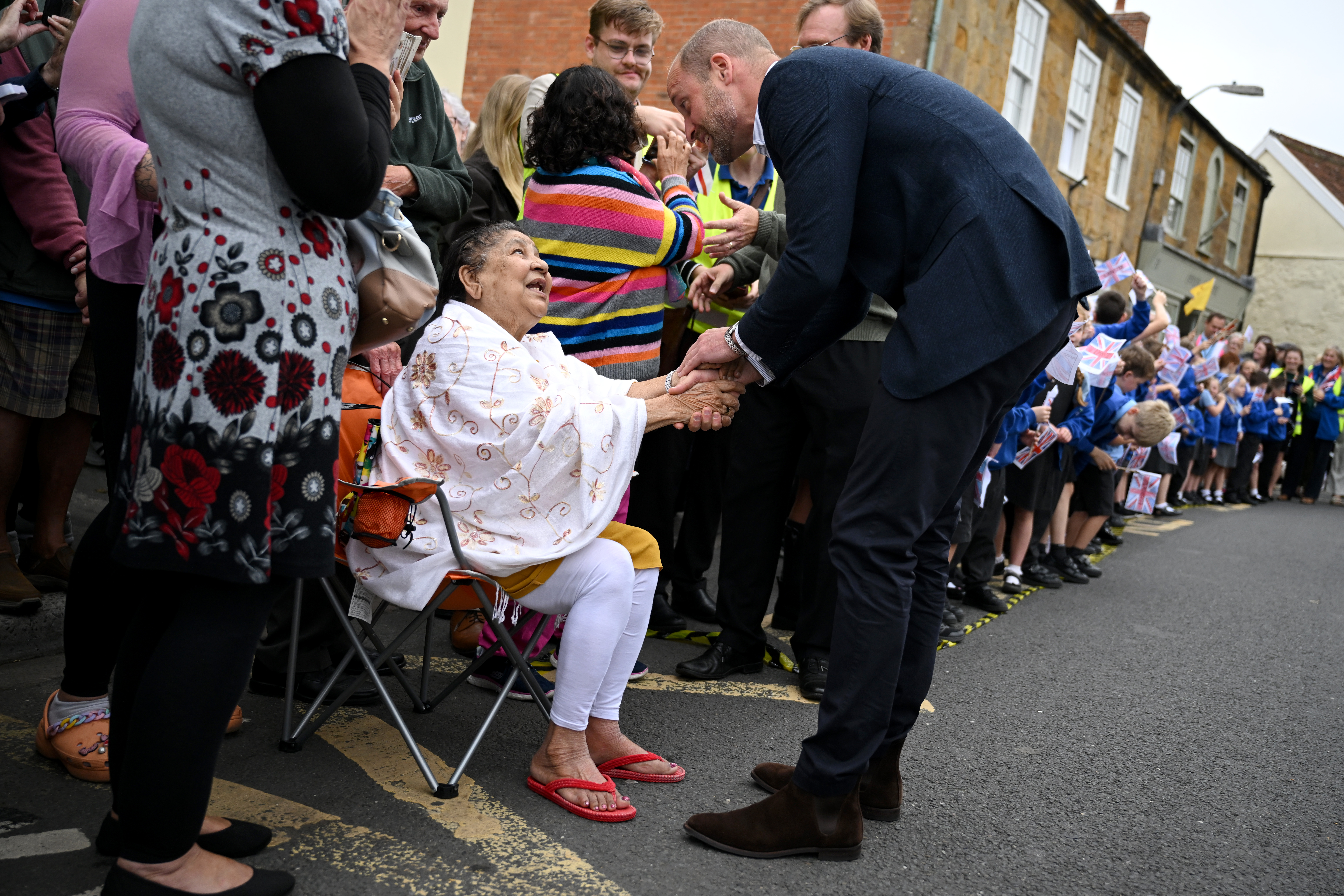 ILMINSTER, ENGLAND - OCTOBER 06: Prince William, Prince of Wales shakes hands with locals during his visit to Sweet Surprise cafe on October 06, 2026 in Ilminster, England. The Prince of Wales visited Ilminster in Somerset to learn about communities growing their resilience to wild fires, flood and challenges caused by extreme weather and global warming. (Photo by Finnbarr Webster/Getty Images)