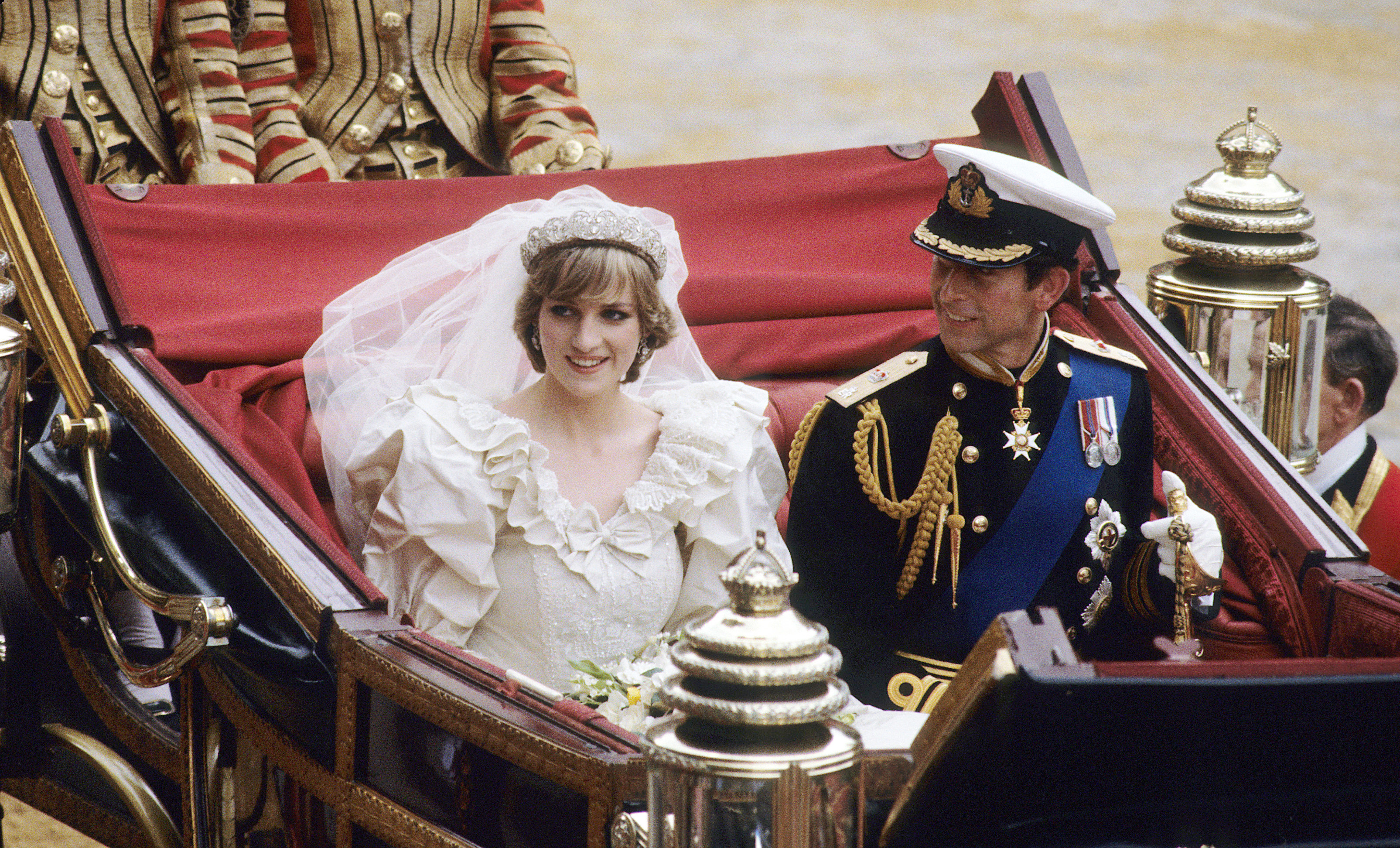 LONDON, ENGLAND - JULY 29: Prince Charles, Prince of Wales and Diana, Princess of Wales, wearing a wedding dress designed by David and Elizabeth Emanuel and the Spencer family Tiara, ride in an open carriage, from St. Paul's Cathedral to Buckingham Palace, following their wedding on July 29, 1981 in London, England.   (Photo by Anwar Hussein/WireImage)