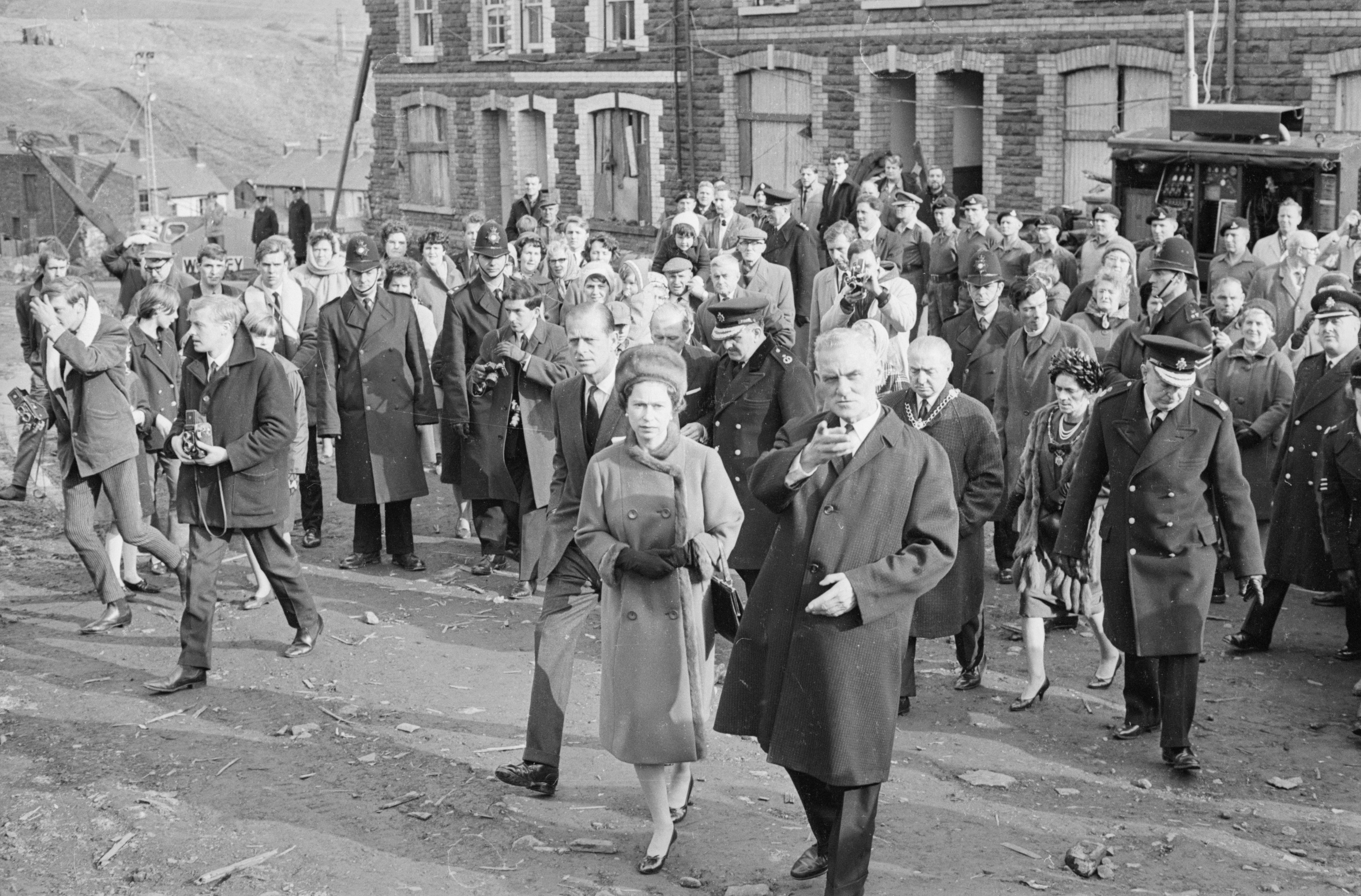 Queen Elizabeth II and Prince Philip visit Aberfan in Wales to comfort the families of the 144 people who died when a coal tip collapsed on the local school.  (Image Source: Getty Images | Stan Meagher/Express)