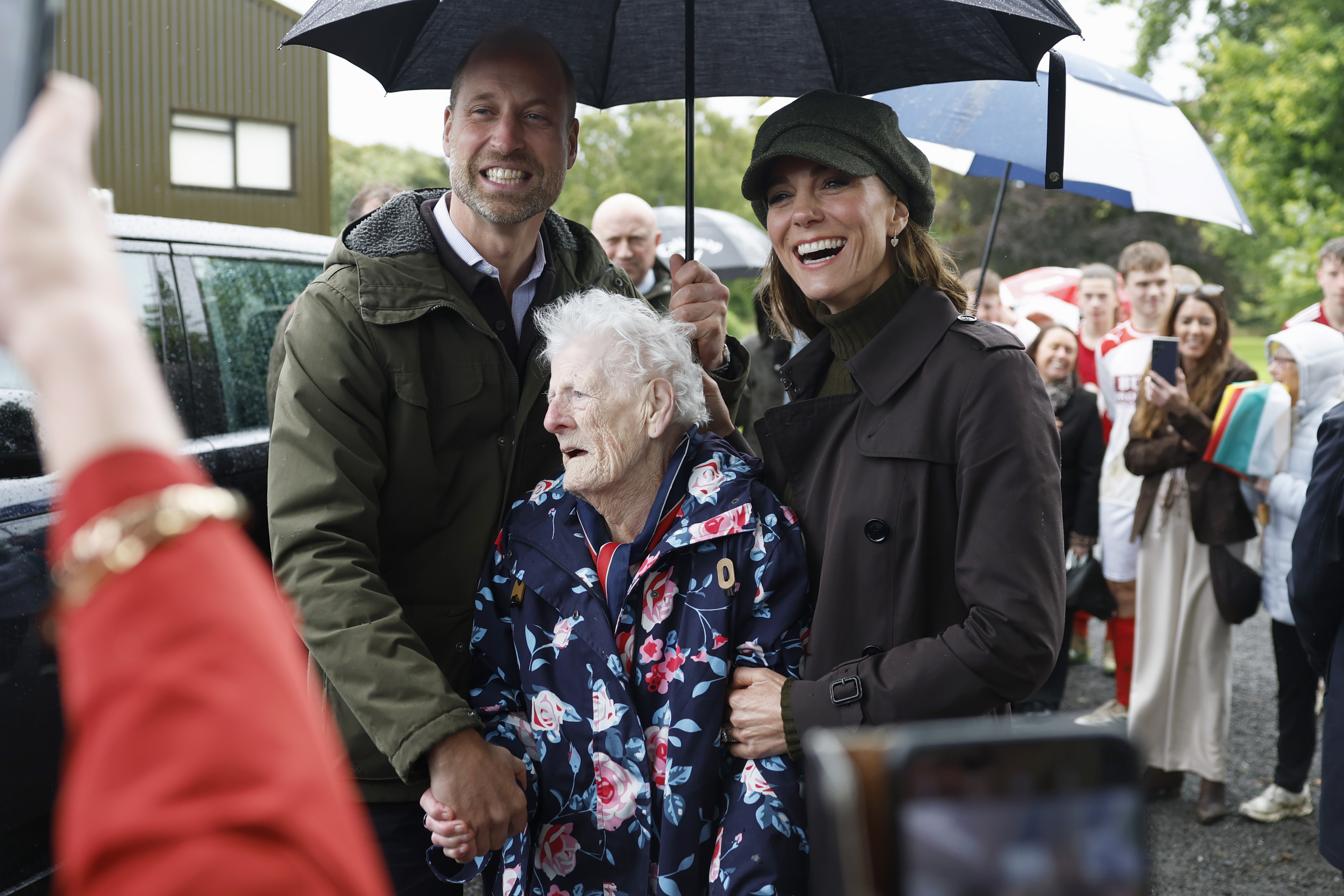ROTHESAY, ISLE OF BUTE, SCOTLAND - SEPTEMBER 17: Prince William, Prince of Wales, and Catherine, Princess of Wales, 
pose with 95-year-old Jenny Salli while visiting Bute Shinty Club in Rothesay, during a royal visit to the Isle of Bute on September 17, 2026 in Rothesay, Isle of Bute, Scotland. The Prince and Princess of Wales, who also hold the titles of The Duke and Duchess of Rothesay, visited the island to celebrate community, connection and volunteering. (Photo by Jeff J Mitchell/Getty Images)