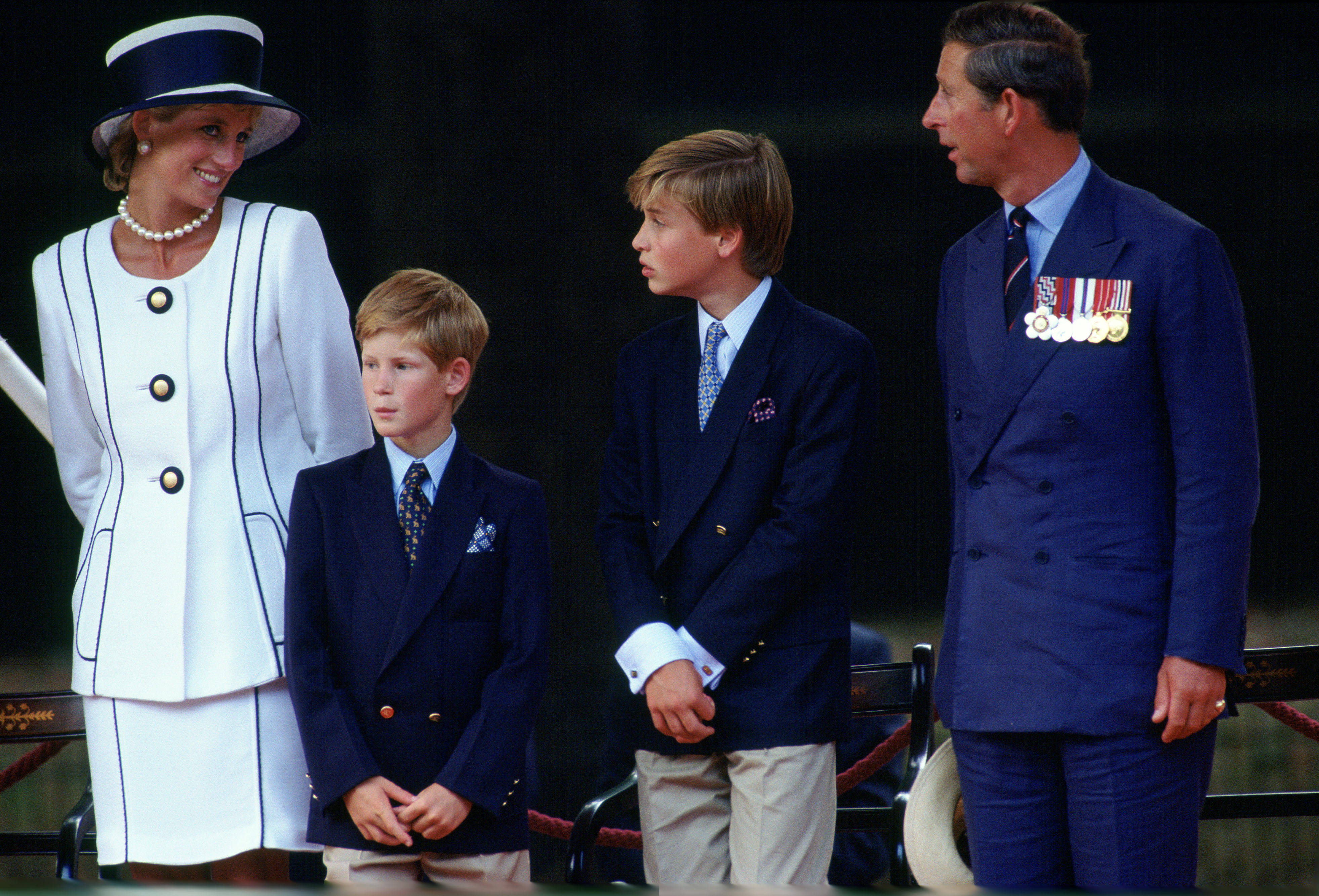 LONDON, UNITED KINGDOM - AUGUST 19:  Prince William And Prince Harry With Their Parents, Diana, Princess Of Wales, And Prince Charles Watching The Vj Day Parade In Pall Mall.  The Princess Is Wearing A Suit Designed By Fashion Designer Tomasz Starzewski.  (Photo by Tim Graham Photo Library via Getty Images)