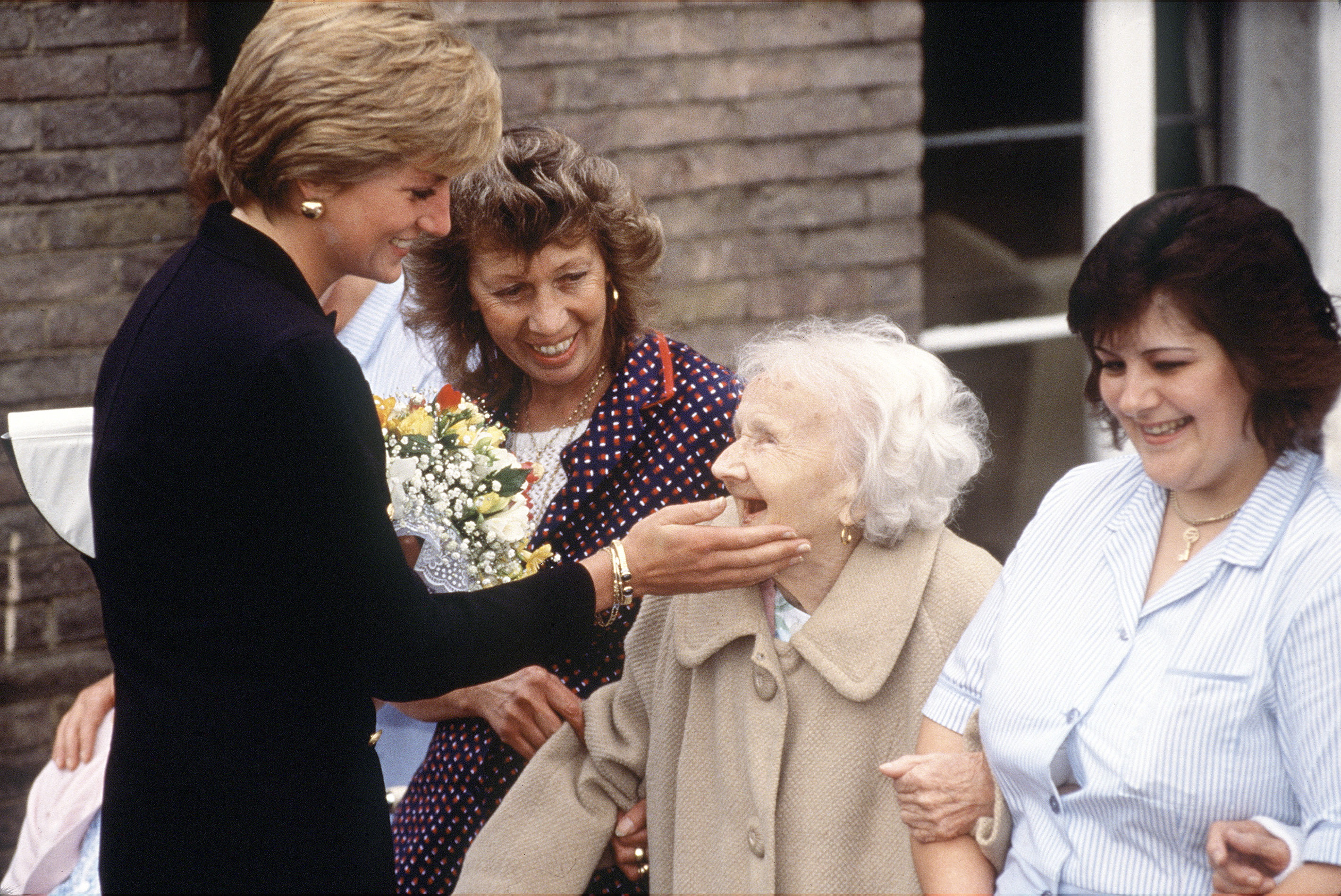 LONDON, UNITED KINGDOM - SEPTEMBER 18:  Princess Diana Visiting The Lord Gage Centre For Old People, A Guinness Trust Home, In Newham, East London.  Princess Diana Is Touching The Face Of An Elderly Lady.  (Photo by Tim Graham Photo Library via Getty Images)