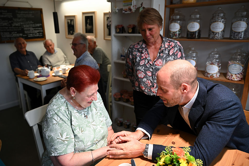ILMINSTER, ENGLAND - OCTOBER 06: Prince William, Prince of Wales speaks with Tina Groves, a local during his visit to Sweet Surprise cafe on October 06, 2026 in Ilminster, England. The Prince of Wales visited Ilminster in Somerset to learn about communities growing their resilience to wild fires, flood and challenges caused by extreme weather and global warming. (Photo by Finnbarr Webster/Getty Images)