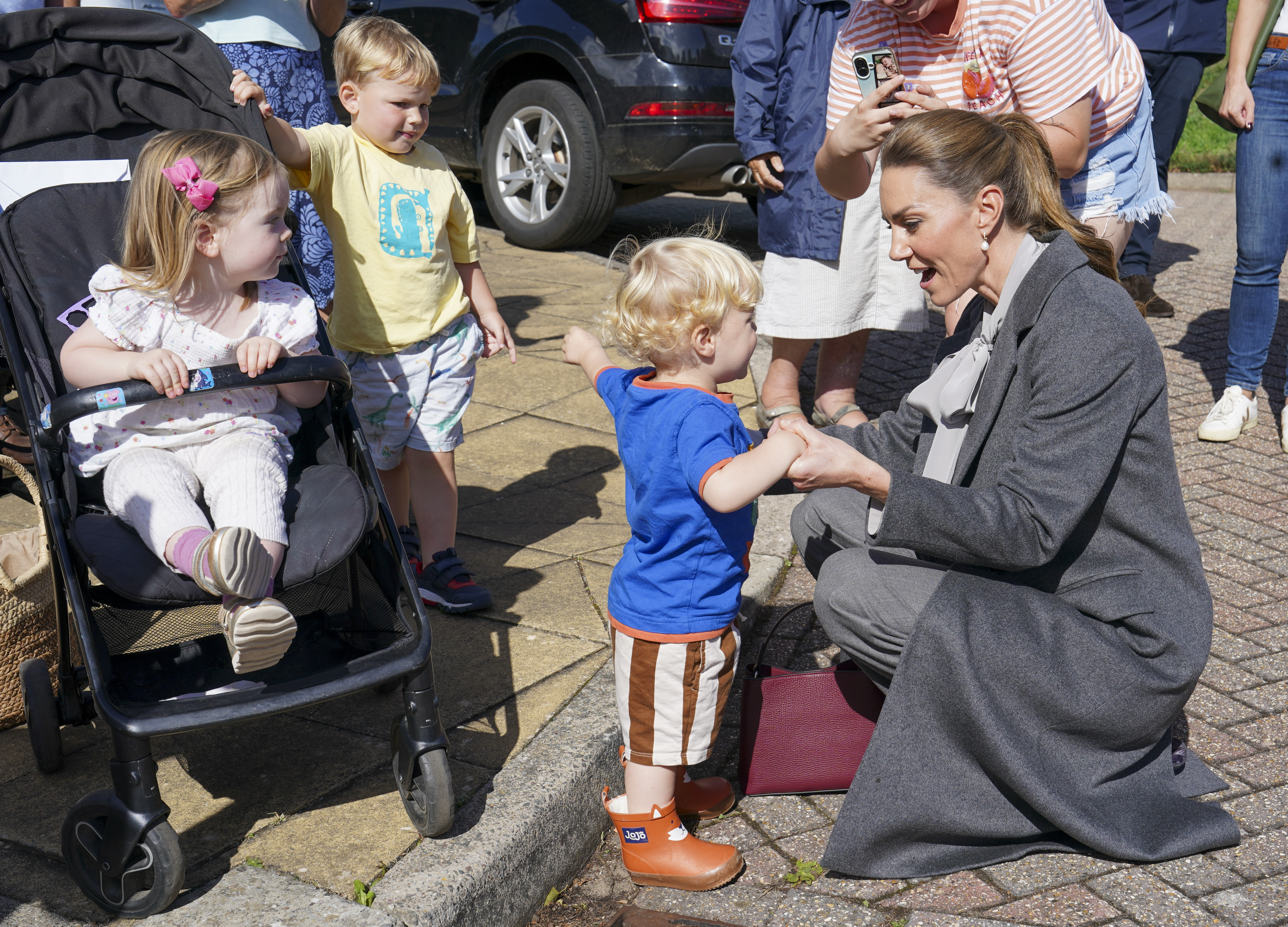 PULBOROUGH, ENGLAND - SEPTEMBER 30: Catherine, Princess of Wales plays with Albie Botley-Greenslade age 1 as she visits West Sussex Minibus, a volunteer-led community transport group, which acts as a vital lifeline for people who cannot easily access public transport due to isolation, mobility challenges or barriers, on September 30, 2026 in Pulborough, England. The Princess's visit highlighted the role community transport plays in bringing people together. (Photo by Arthur Edwards - WPA Pool/Getty Images)