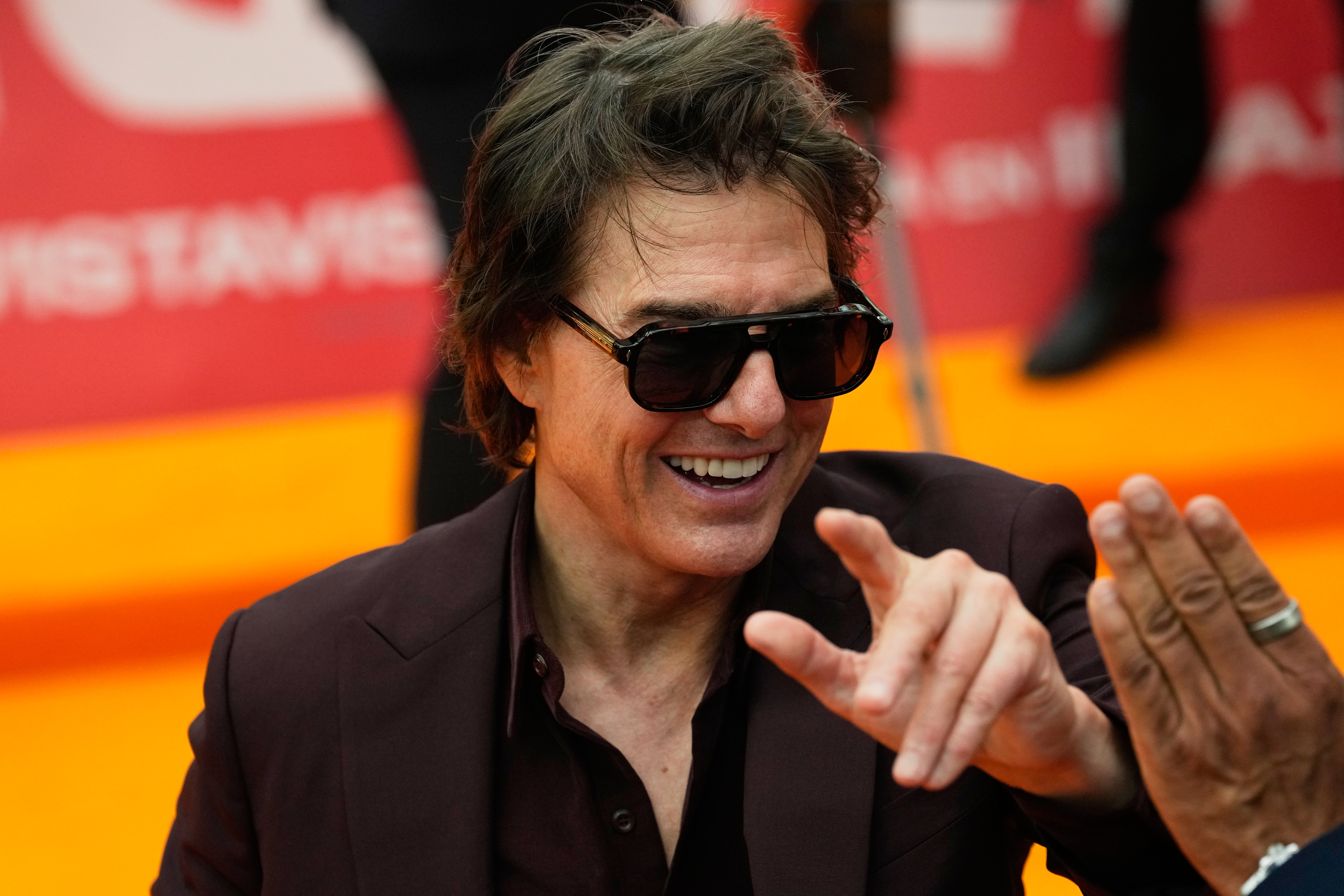 Tom Cruise greets fans during a red carpet fan event promoting the film