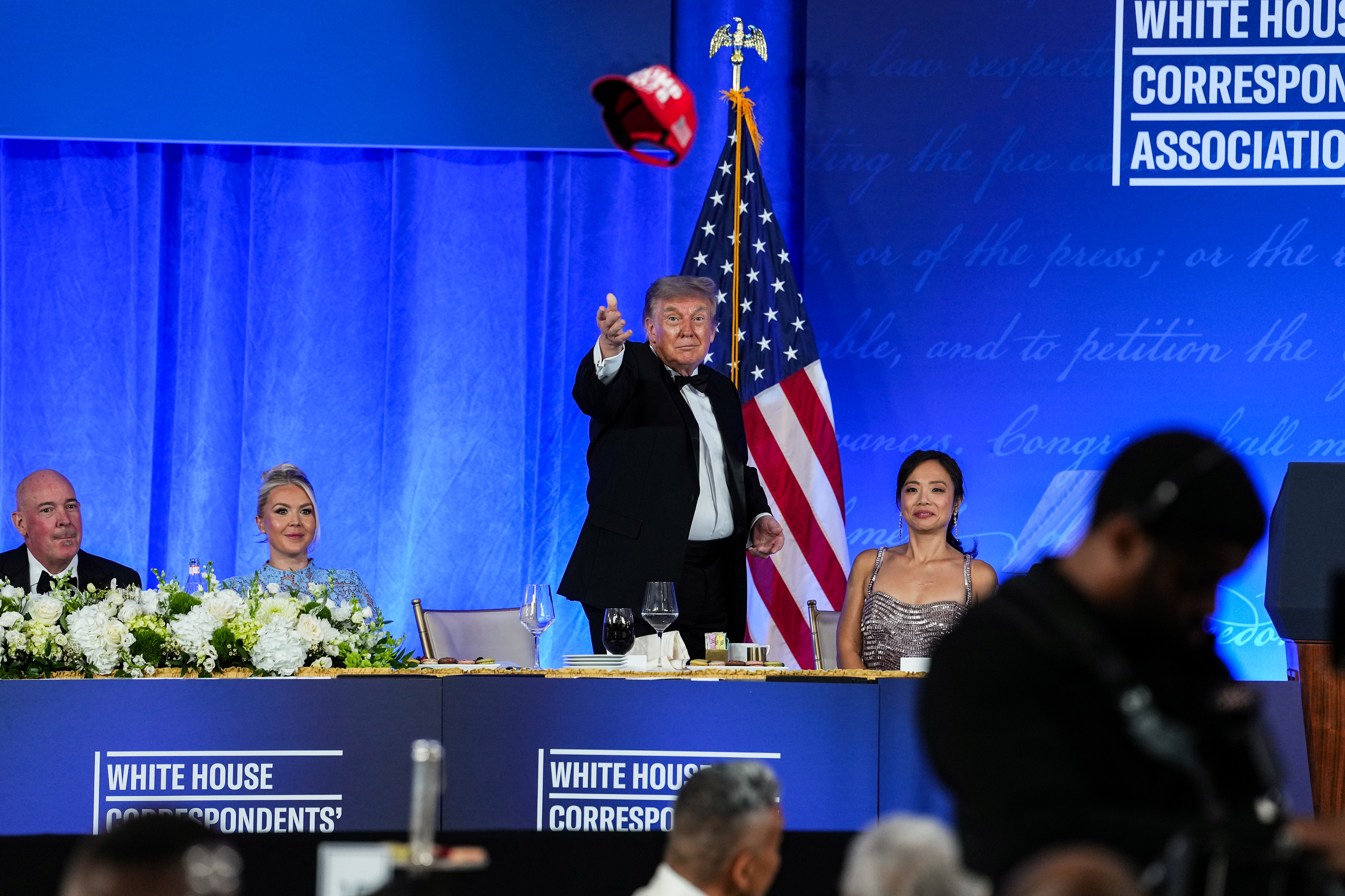 WASHINGTON, DC - JULY 24: U.S. President Donald Trump tosses his TRUMP 2028 hat to an attendee during the re-scheduled White House Correspondents Dinner in the Presidential Ballroom at the Waldorf Astoria on July 24, 2026 in Washington, DC. The annual gala hosted by the White House Correspondents Association was re-scheduled to tonight after the original event in April was cut short when an armed man, later identified as Cole Tomas Allen, attempted to get past a Secret Service checkpoint. (Photo by Eric Lee/Getty Images)
