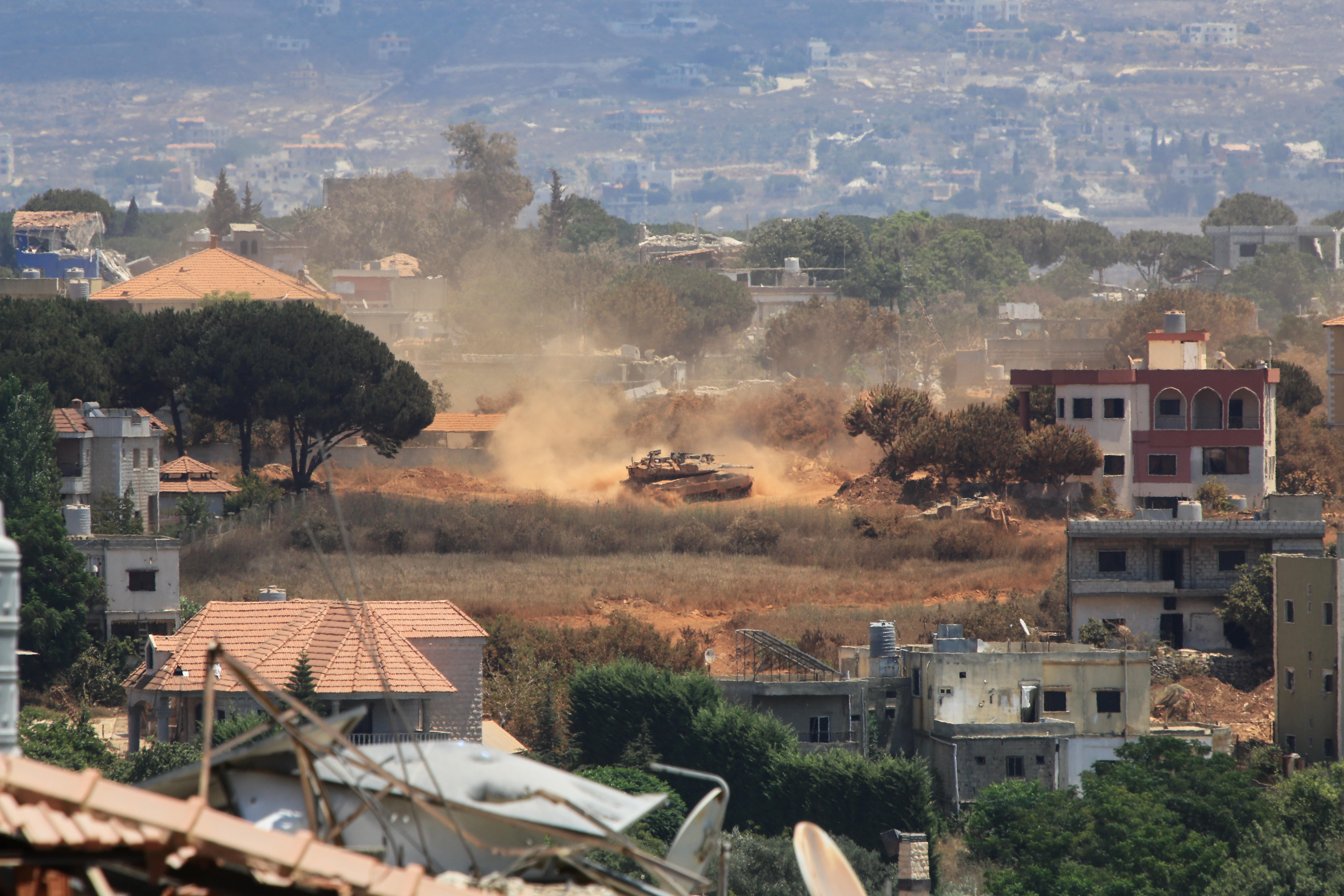 An Israeli tank drives through Zawtar al-Sharqiyah village, occupied by Israeli forces, as seen from the southern village of Zawtar al-Gharbieh, Lebanon, Monday, July 27, 2026. (Image Source: AP | Photo by Mustafa Jamalddine)