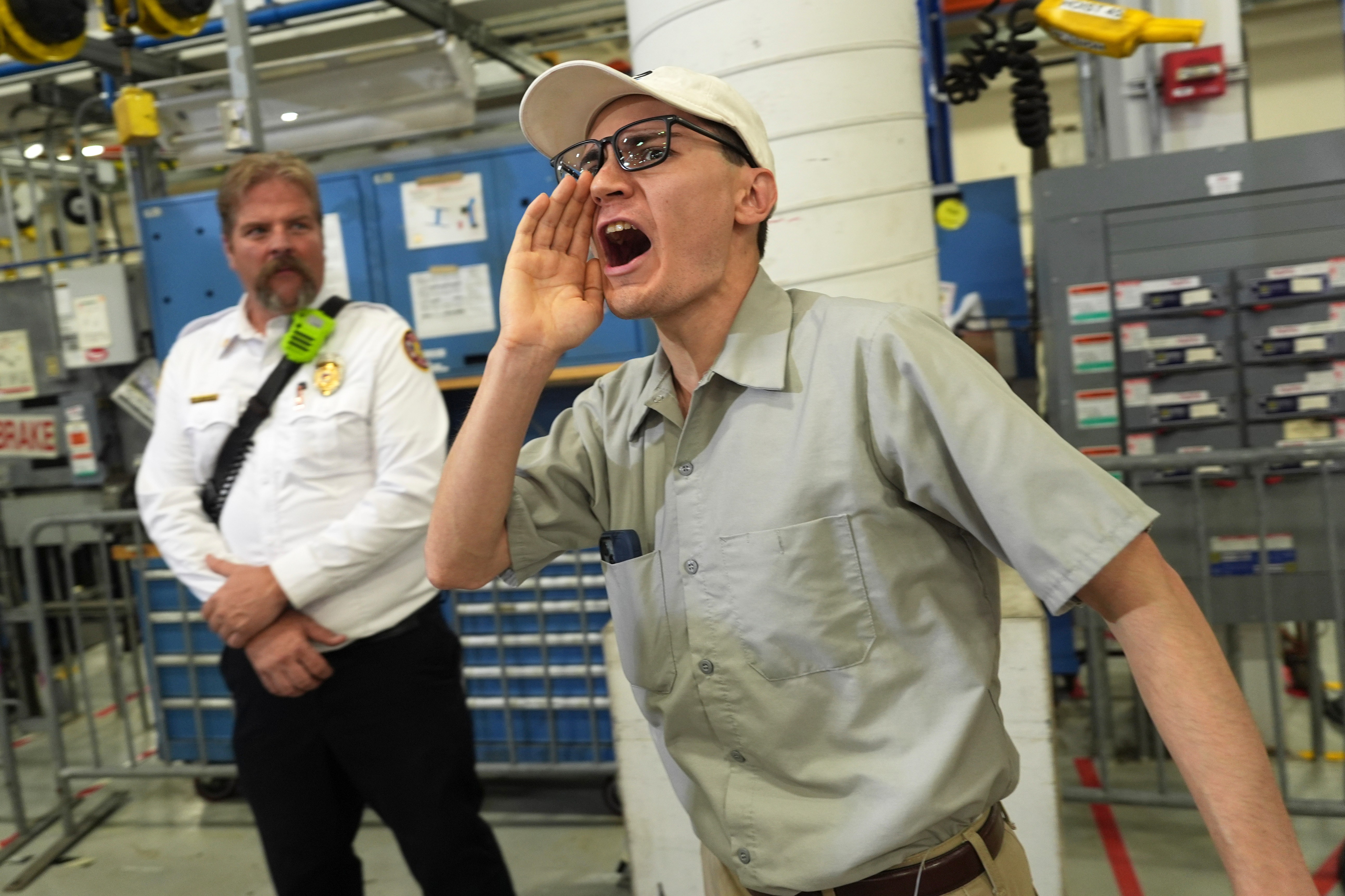 A protestor shouts as President Donald Trump speaks at General Motors proving ground, Monday, July 27, 2026, in Milford, Mich. (AP Photo/Alex Brandon)