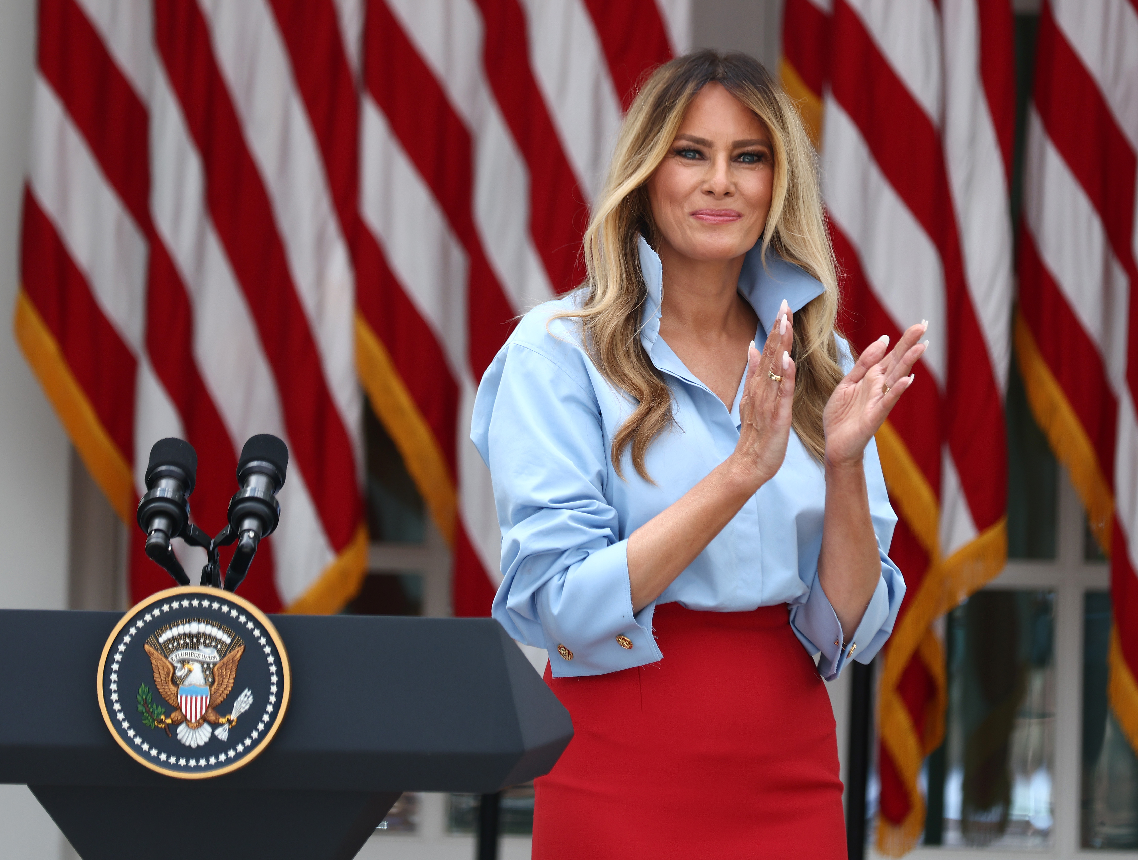 WASHINGTON, DC - AUGUST 20: First lady Melania Trump stands on stage during an event announcing the expansion of a foster care initiative in the Rose Garden of the White House on August 20, 2026 in Washington, DC. The event focused on the first lady's “Foster the Future” initiative, with plans to expand opportunities for individuals transitioning from foster care. (Photo by Finn Gomez/Getty Images)