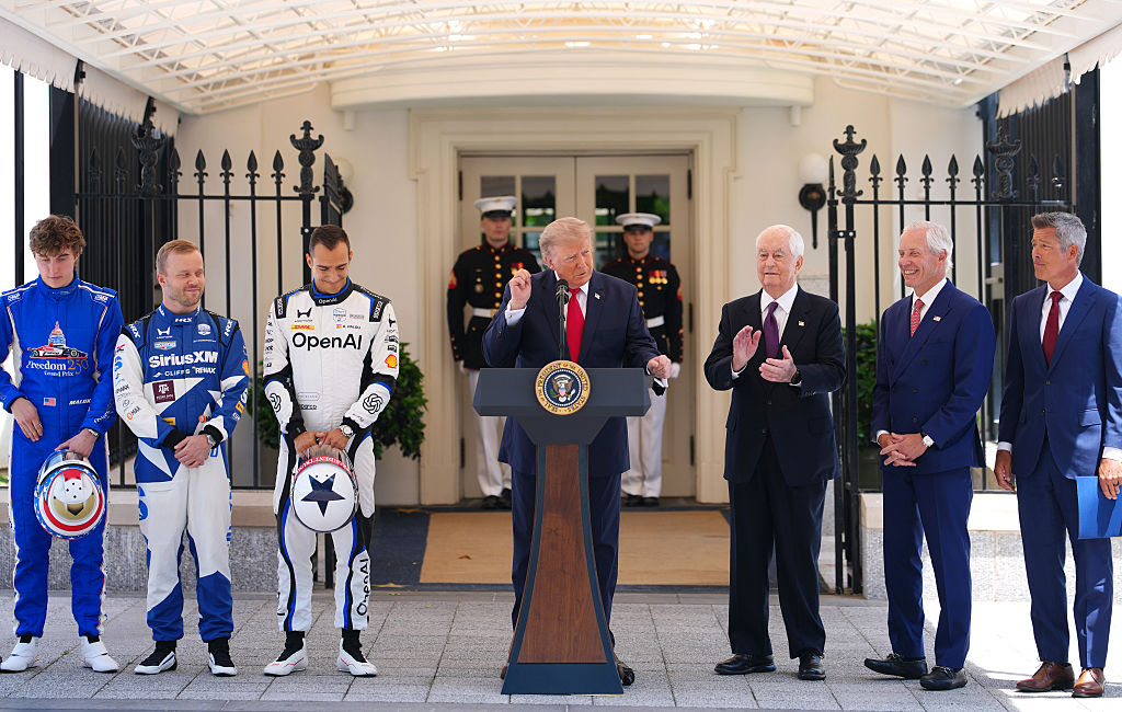 WASHINGTON, DC - JULY 13: U.S. President Donald Trump speaks as (L-R) IndyCar series driver David Malukas, 2026 Indianapolis 500 winner Felix Rosenqvist, reigning IndyCar series champion Alex Palou, Penske Corporation CEO Roger Penske, Freedom 250 Grand Prix Chairman Bud Denker, and Secretary of Transportation Sean Duffy look on at a Freedom 250 Grand Prix showcase on West Executive Avenue between the West Wing of the White House and the Eisenhower Executive Office Building on July 13, 2026 in Washington, DC. The IndyCar Freedom 250 Grand Prix car race, August 22 and 23 on the National Mall, is part of America's 250th anniversary celebrations.  (Photo by Andrew Harnik/Getty Images)