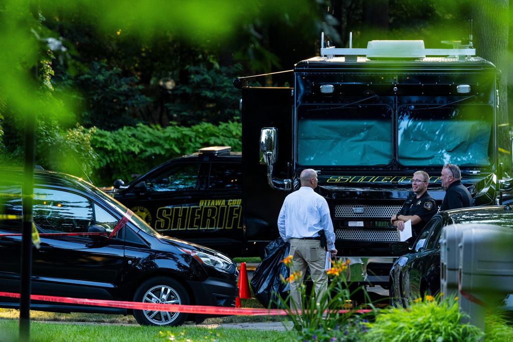 Law enforcement officials investigate the scene of a fatal house fire on Friday, July 24, 2026, in Grand Haven Township, Mich. (Joel Bissell/Kalamazoo Gazette via AP)