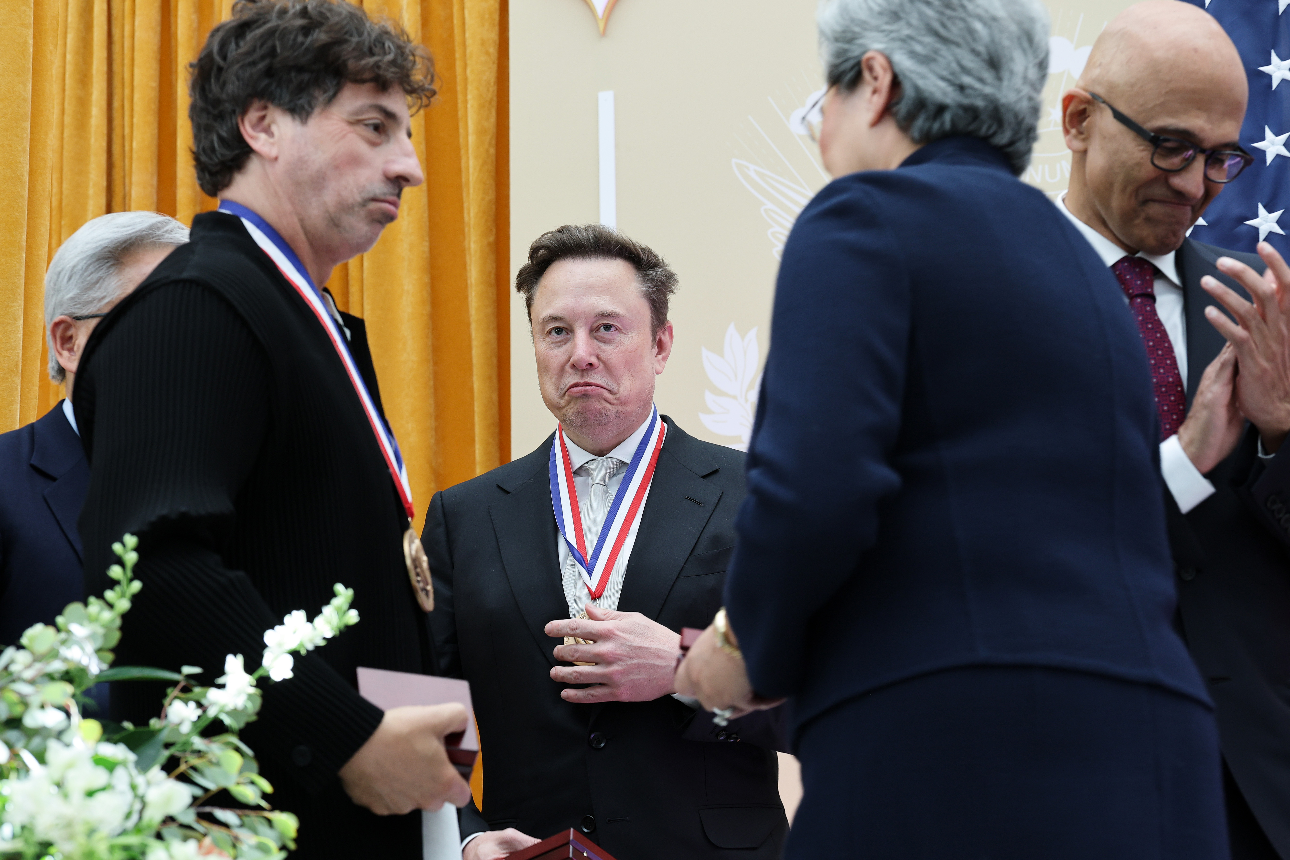 WASHINGTON, DC - OCTOBER 08: Tesla and SpaceX CEO Elon Musk (C) reacts after being awarded the National Medal of Science during the Golden Age of American Innovation Summit at the Institute of Peace on October 08, 2026 in Washington, DC. Trump awarded some of the nation's highest scientific honors to technology leaders including Elon Musk, Sergey Brin, Jensen Huang, Lisa Su, Michael Dell, and Satya Nadella. (Photo by Win McNamee/Getty Images)