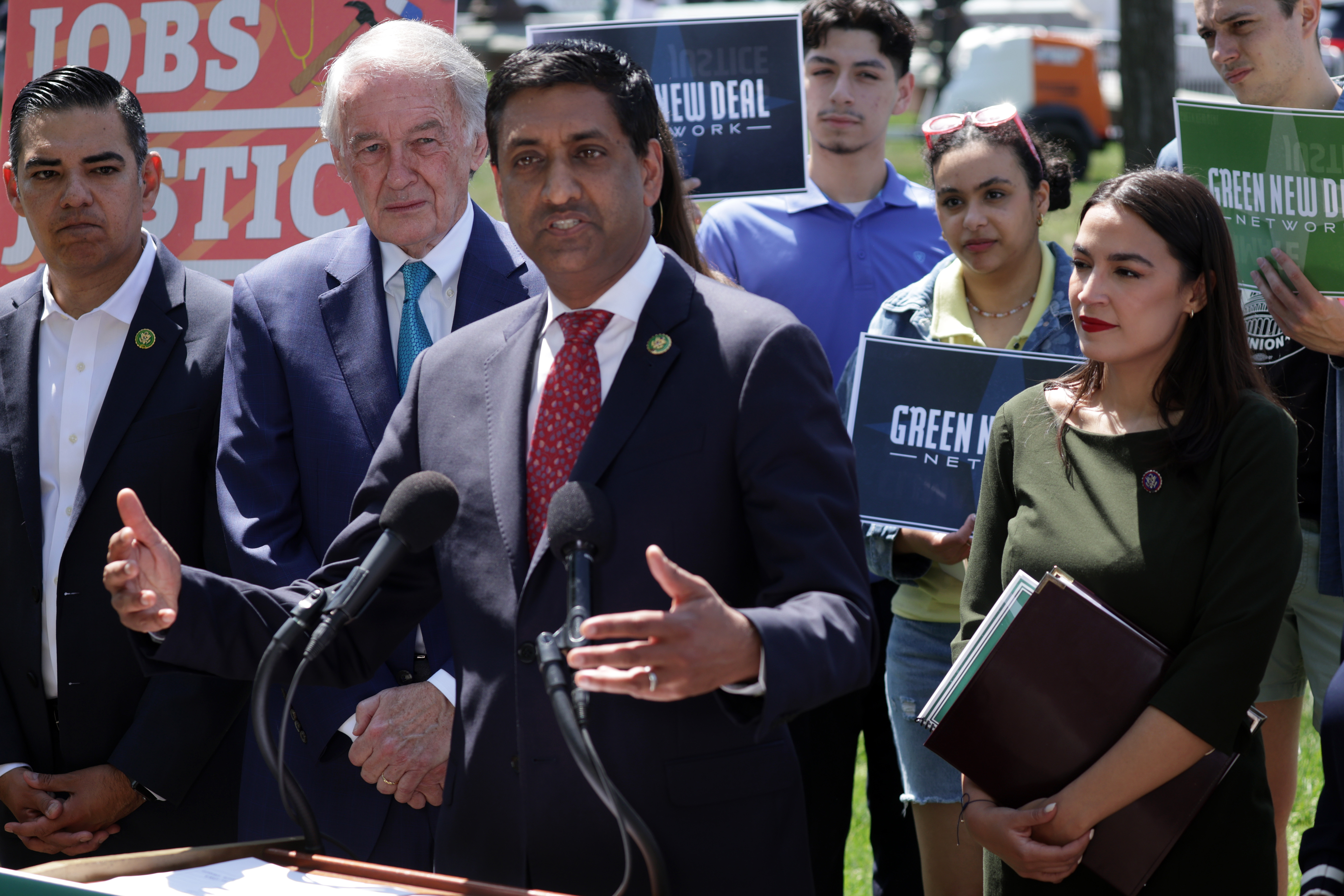 WASHINGTON, DC - APRIL 20: U.S. Rep. Ro Khanna (D-CA) (3rd L) speaks as Sen. Ed Markey (D-MA) (2nd L), Rep. Alexandria Ocasio-Cortez (D-NY) (R) and other participants listen during a news conference on the “Green New Deal” in front of the U.S. Capitol on April 20, 2023 in Washington, DC. The lawmakers held a news conference to reintroduce the