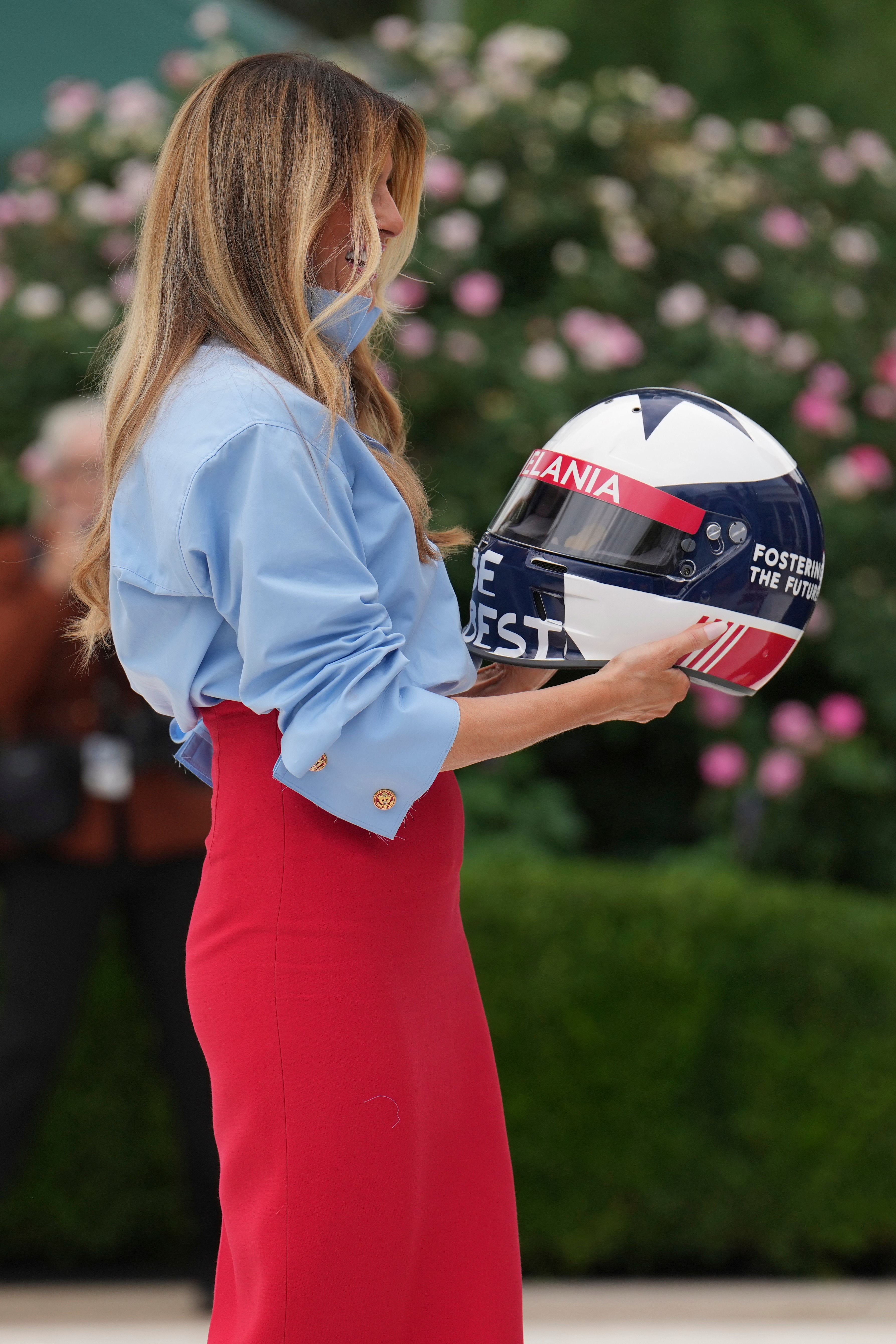 First lady Melania Trump holds a helmet presented to her by IndyCar series drivers at an event in the Rose Garden of the White House, Thursday, Aug. 20, 2026, in Washington. (AP Photo/Jacquelyn Martin)