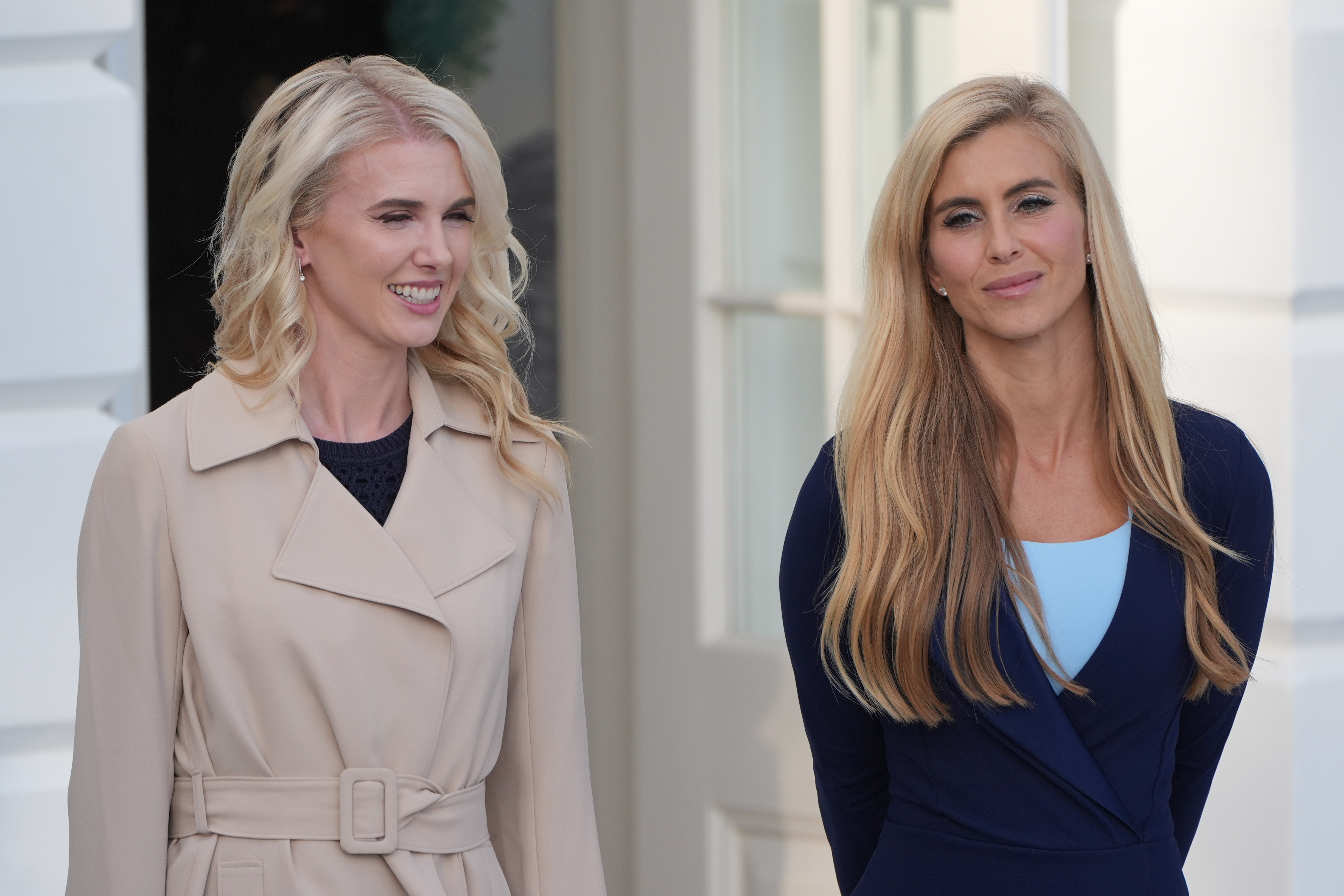 White House aide Natalie Harp, left, stands with White House press secretary Katie Zacharia as President Donald Trump speaks with reporters before departing on Marine One from the South Lawn of the White House, Monday, Oct. 12, 2026, in Washington. (AP Photo/Alex Brandon)