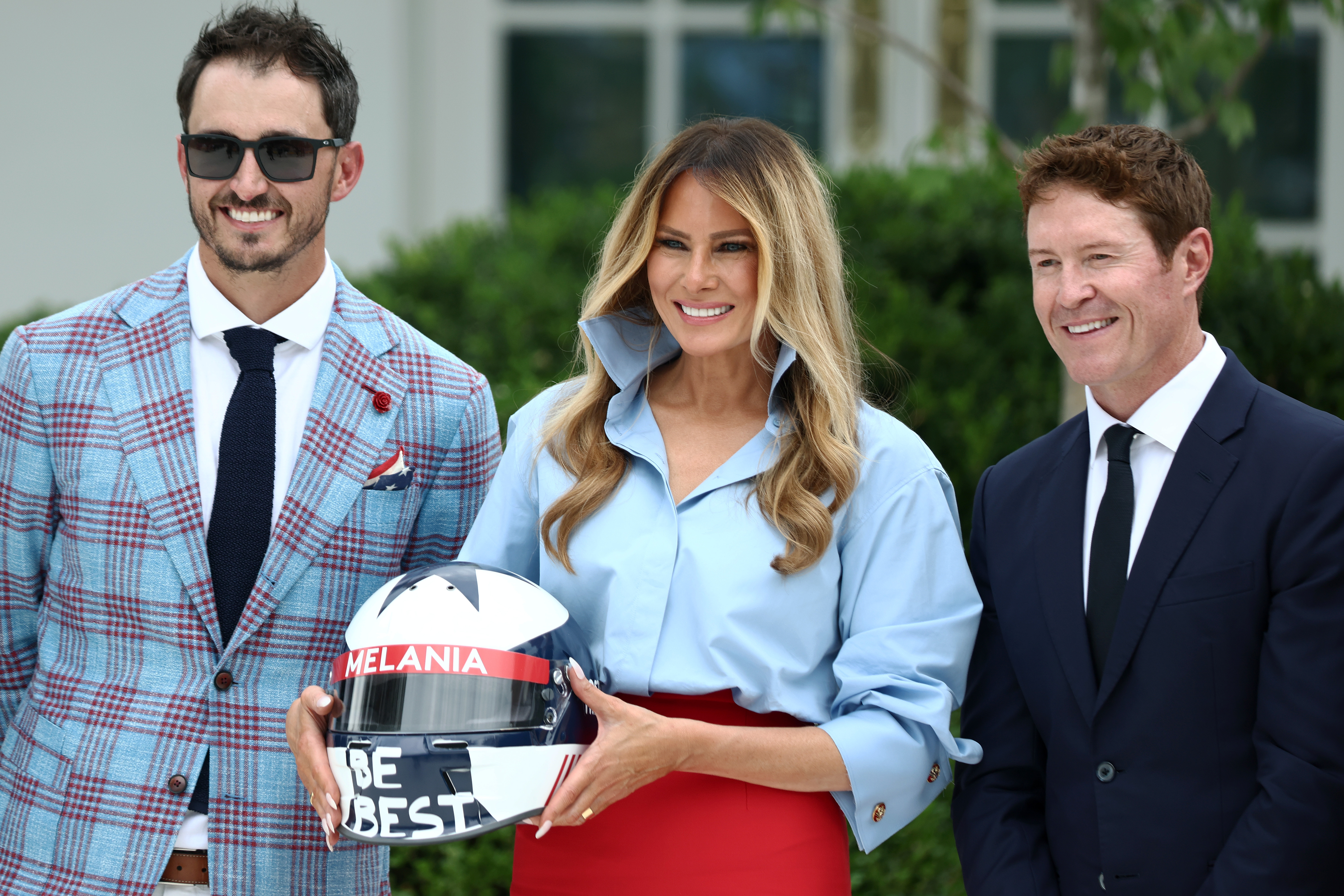 WASHINGTON, DC - AUGUST 20: (L-R) IndyCar driver Alexander Rossi,  first lady Melania Trump, and IndyCar driver Scott Dixon pose during an event announcing the expansion of a foster care initiative in the Rose Garden of the White House on August 20, 2026 in Washington, DC. The event focused on the first lady's “Foster the Future” initiative, with plans to expand opportunities for individuals transitioning from foster care. (Photo by Finn Gomez/Getty Images)