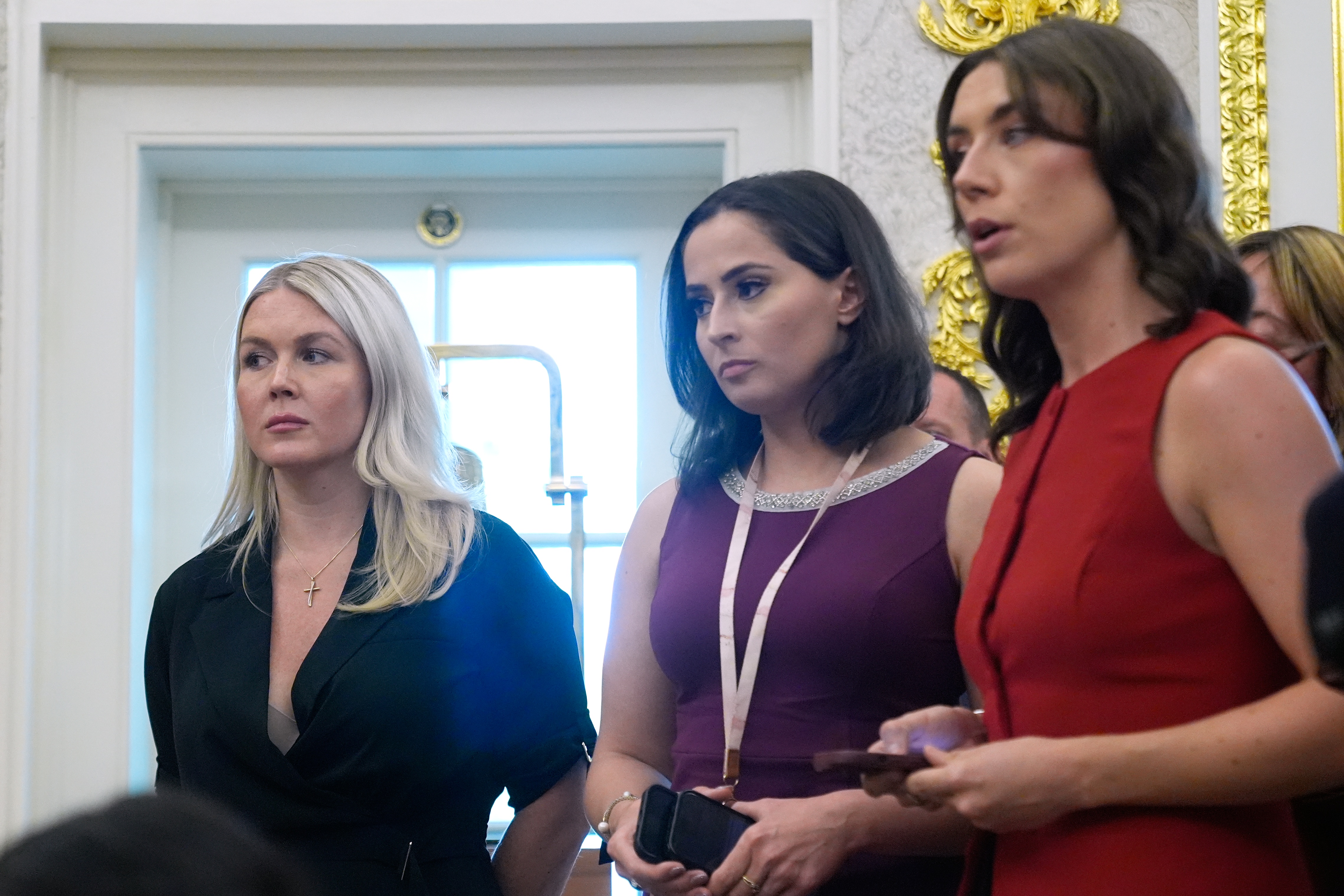 White House press secretary Karoline Leavitt listens as President Donald Trump speaks as he meets with lifeguard Ryder Williams in the Oval Office of the White House, Monday, Aug. 17, 2026, in Washington. (AP Photo/Manuel Balce Ceneta)