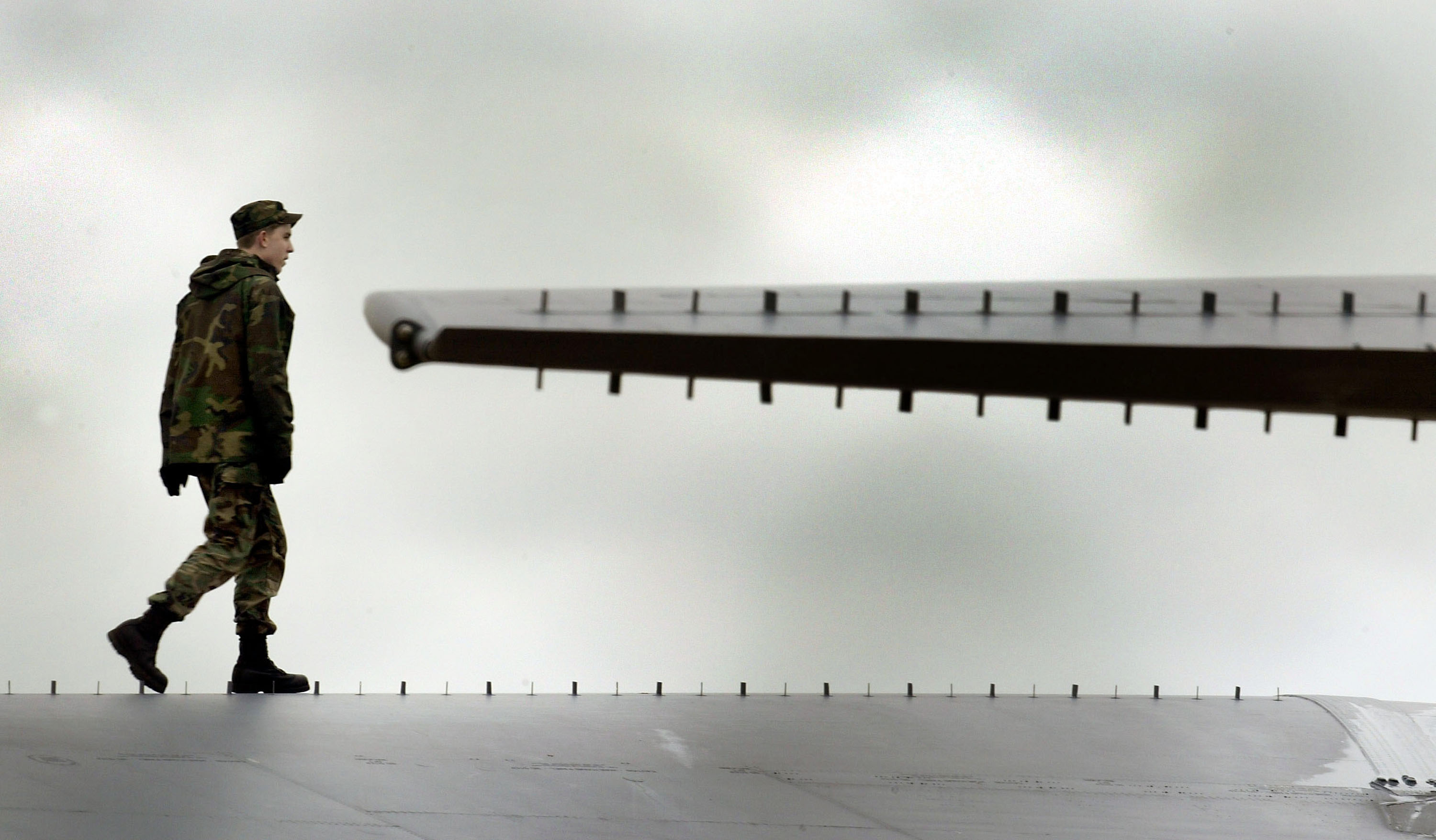 GLOUESTERSHIRE, UNITED KINGDOM - MARCH 4:  A U.S. serviceman walks near the wing of an American B-52 bomber after it landed at Fairford Royal Air Force (RAF) base March 4, 2003 in Gloucestershire, United Kingdom. The last time the bombers were stationed on British soil was for the attacks on Yugoslavia four years ago.  (Photo by Scott Barbour/Getty Images)