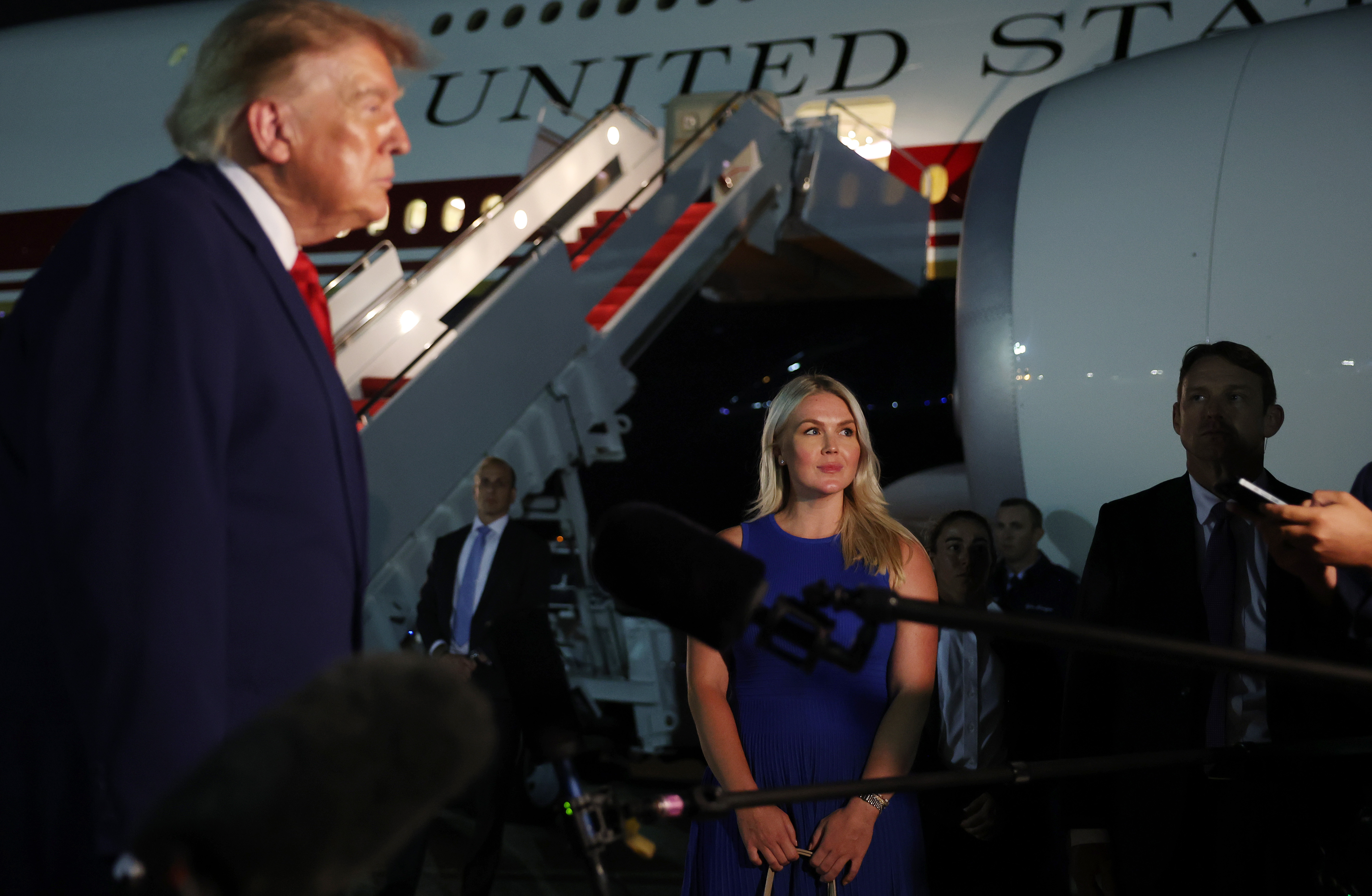 JOINT BASE ANDREWS, MARYLAND - AUGUST 11: White House Press Secretary Karoline Leavitt looks on as U.S. President Donald Trump speaks to reporters after stepping off Air Force One on August 11, 2026 in Joint Base Andrews, Maryland. Trump was asked about the secret decoy flight he took out of Turkey in a military aircraft. The president returning to Washington, DC after traveling to Ohio to attend the 2026 Patriot Games. (Photo by Anna Moneymaker/Getty Images)