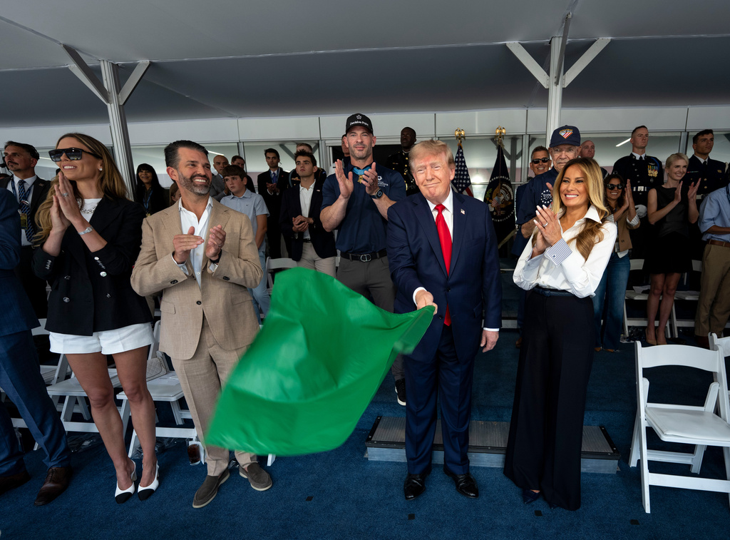 President Donald Trump waves the green flag to start the race alongside first lady Melania Trump, right, and from left, Bettina Trump and Donald Trump Jr. during the IndyCar Freedom 250 Grand Prix auto race, Sunday, Aug. 23, 2026, in Washington. (Doug Mills/The New York Times via AP, Pool)