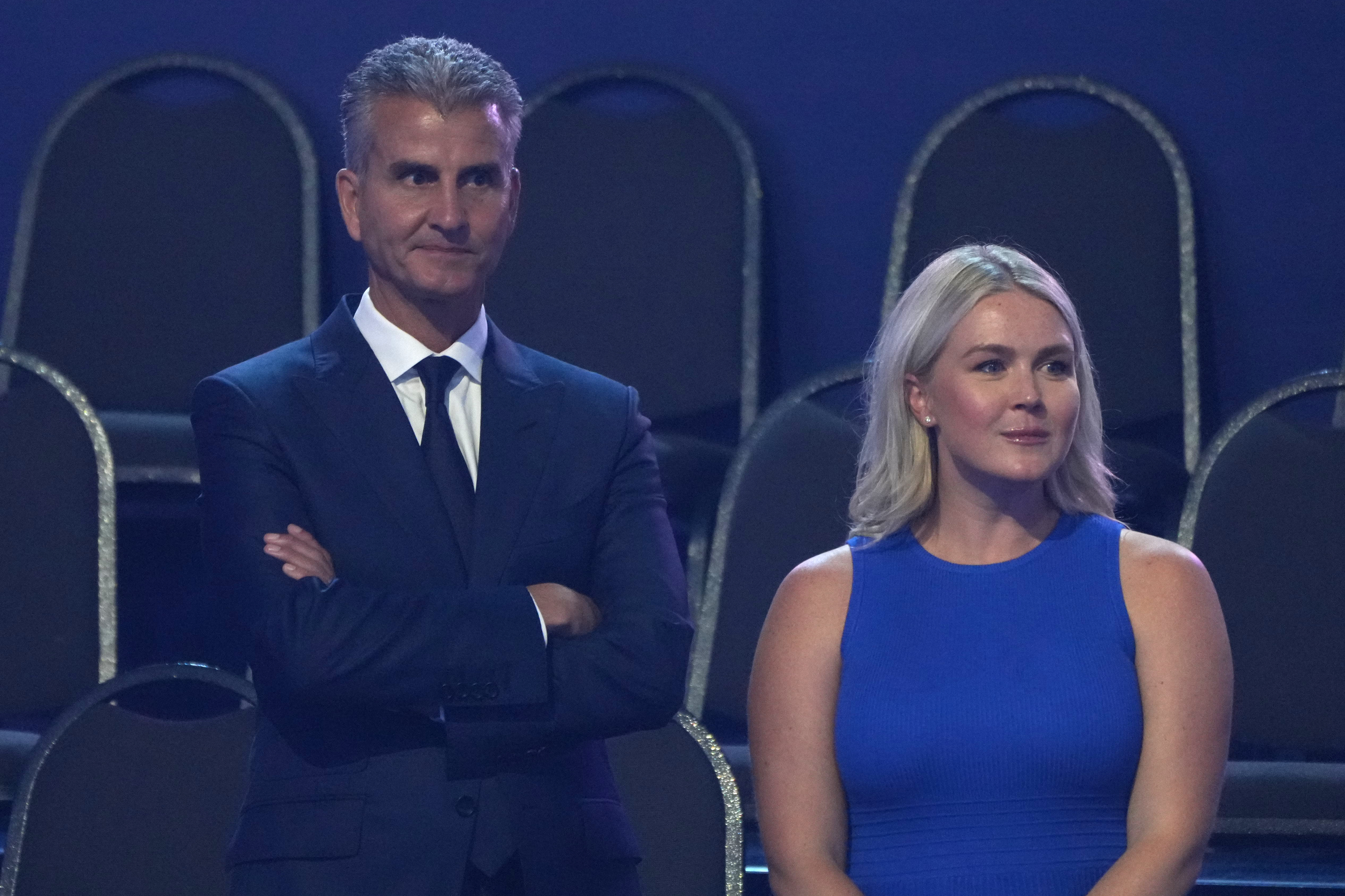 Josh D'Amaro, CEO of The Walt Disney Company, stands with White House press secretary Karoline Leavitt before President Donald Trump attends the Patriot Games at Spire Academy in Geneva, Ohio, Tuesday, Aug. 11, 2026. (AP Photo/Mark Schiefelbein)