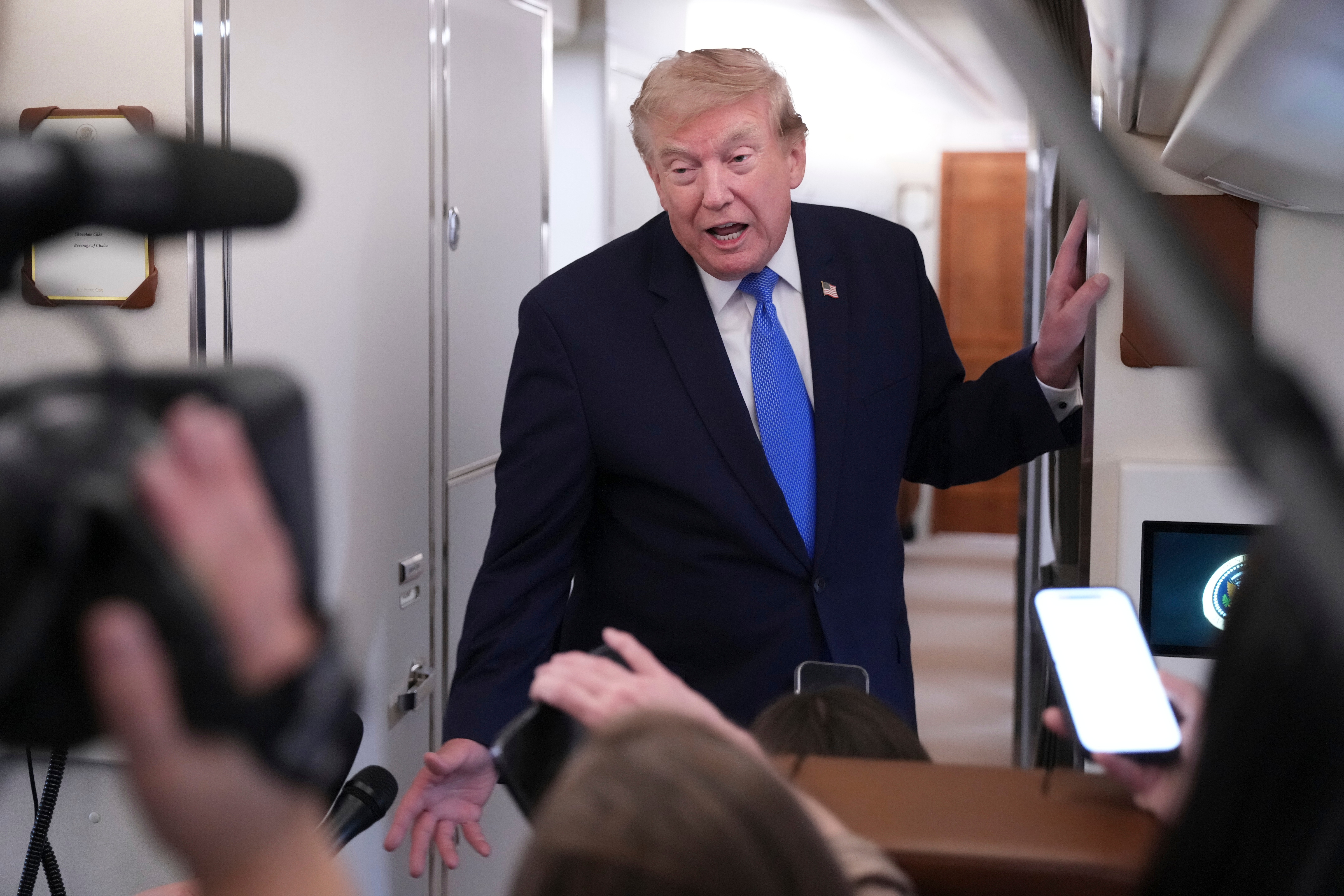 President Donald Trump speaks to reporters onboard Air Force One while returning to the White House, Sunday, Aug. 2, 2026. (AP Photo/Jacquelyn Martin)