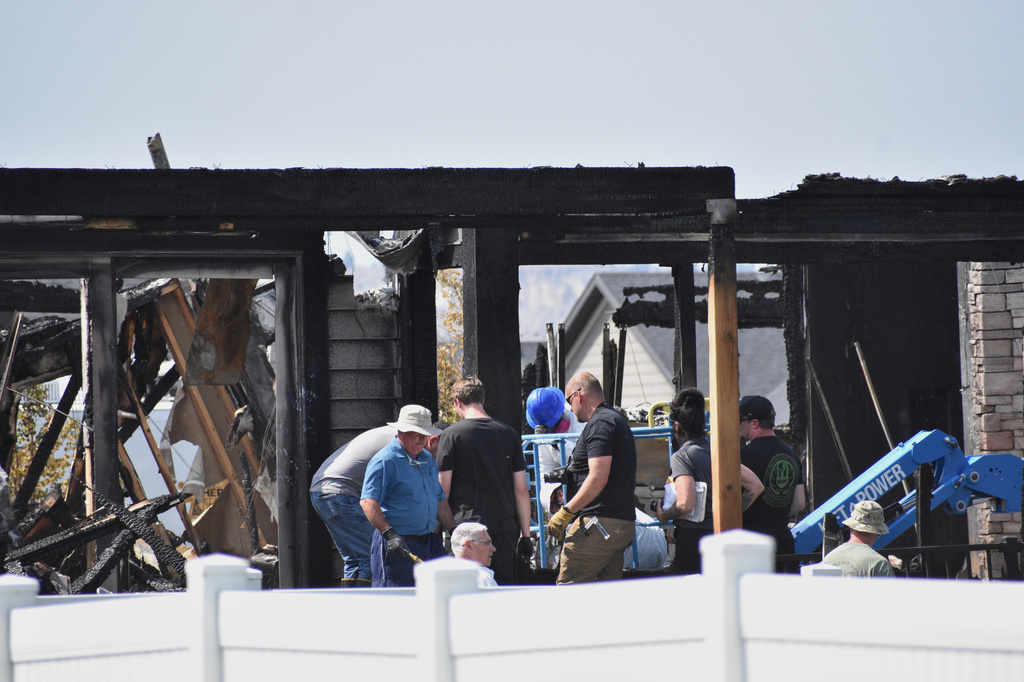 Investigators work at the scene Tuesday, Aug. 25, 2026, where a family was killed and the house burned in Billings, Mont. (AP Photo/Matthew Brown)