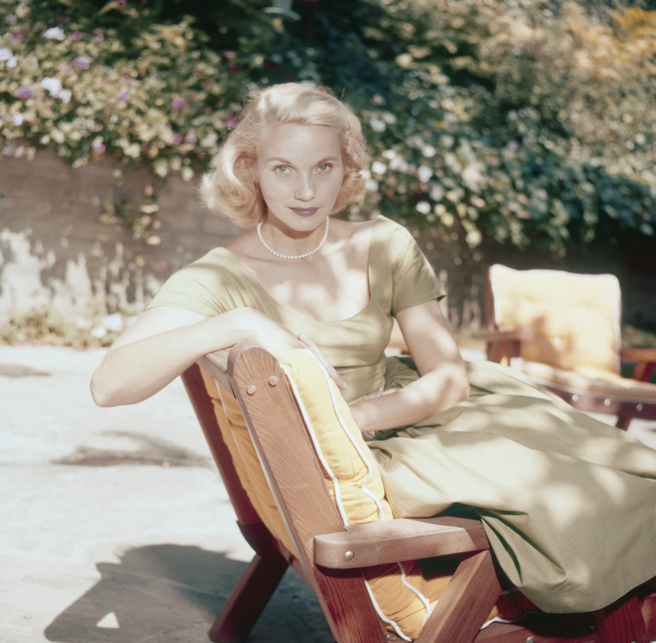 Actress Eva Marie Saint pictured seated on a sun lounger in a garden, USA, circa 1950. Saint is wearing a light green dress and a pearl necklace (Archive Photos/Getty Images)