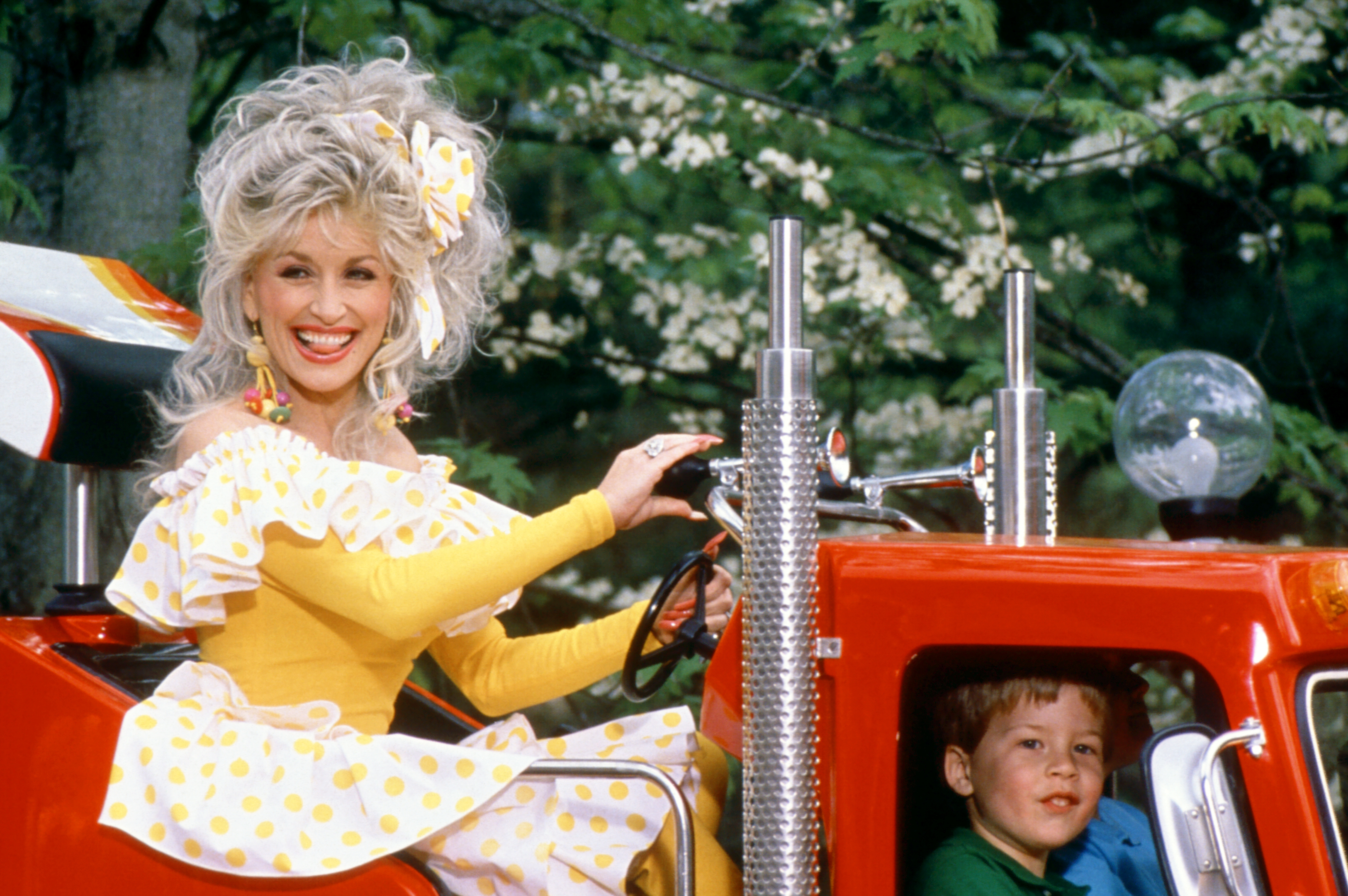 PIGEON FORGE, TN - 1997: American singer and songwriter Dolly Parton rides on a truck at her Dollywood theme park circa 1997 in Pigeon Forge, Tennessee.  (Photo by Ron Davis/Getty Images)