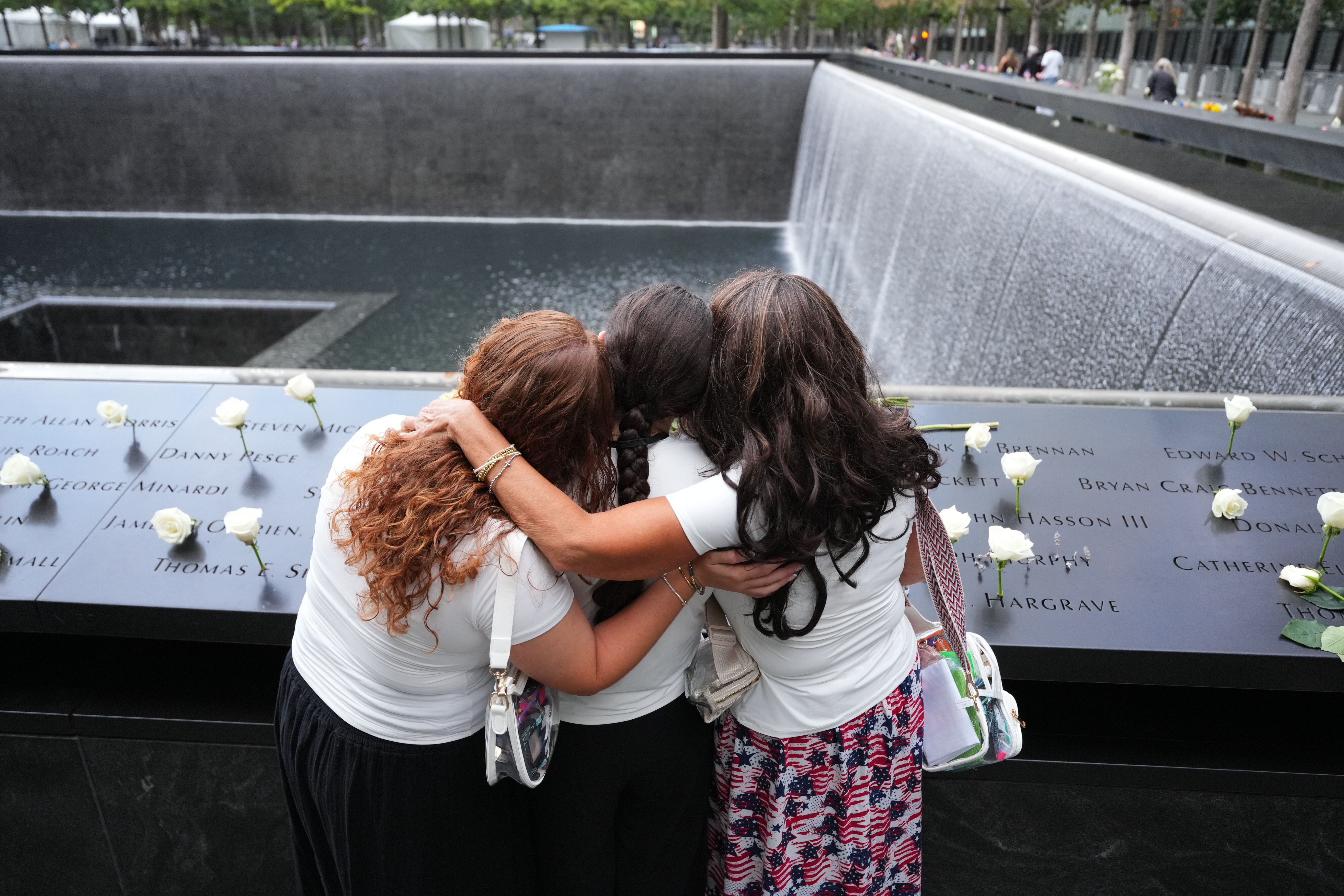 NEW YORK, NEW YORK - SEPTEMBER 11: Rosanne Spirito, 49, and daughters Sabrina, 22, and Amanda, 20, who lost their sister Catherine Lisa LoGuidice, stand at a reflecting pool on the 25th anniversary of the September 11th terrorist attacks on the World Trade Center at the National 9/11 Memorial & Museum on September 11, 2026, in New York City. The United States is marking the 25th anniversary of the terrorist attacks of September 11, 2001, when a group of al-Qaeda hijackers flew airplanes into the World Trade Center, Shanksville, Pennsylvania, and the Pentagon, killing nearly 3,000 people. (Photo by Adam Gray - Pool/Getty Images)