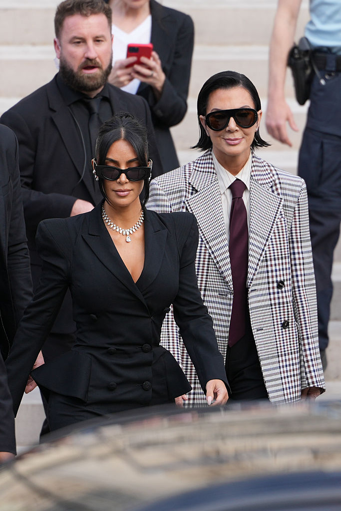 PARIS, FRANCE - MAY 13: Kim Kardashian and Kris Jenner exit the trial at the Palais de Justice ; Kim Kardashian wears sunglasses by Alaia, a black dress with power shoulders / shoulder pads / puff shoulders and low-neck by John Galliano, a necklace by Samer Halimeh, Repossi diamond earcuffs, Brioni Raymond earrings, at the Palais de Justice, on May 13, 2025 in Paris, France. (Photo by Edward Berthelot/GC Images)