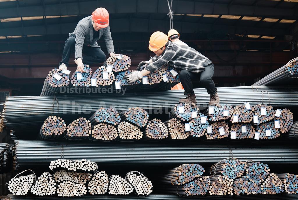 Workers lift steel at a steel market on March 31, 2026 in Hangzhou, Zhejiang Province of China. (Long Wei/VCG via AP )