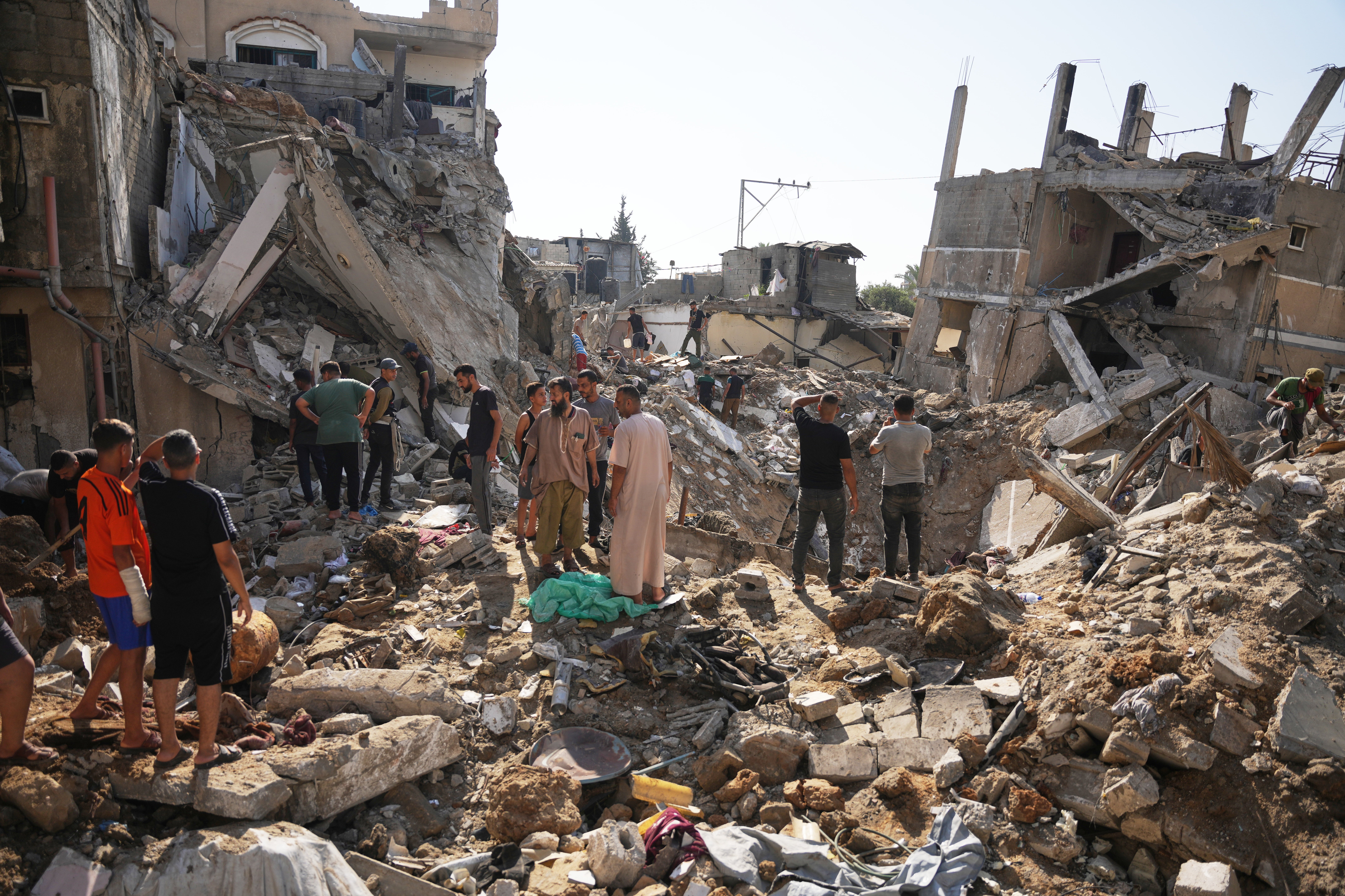Palestinians inspect destroyed buildings at the scene of an Israeli airstrike, at al-Maghazi refugee camp, central Gaza Strip, Saturday, Aug. 1, 2026. (AP Photo/Abdel Kareem Hana)