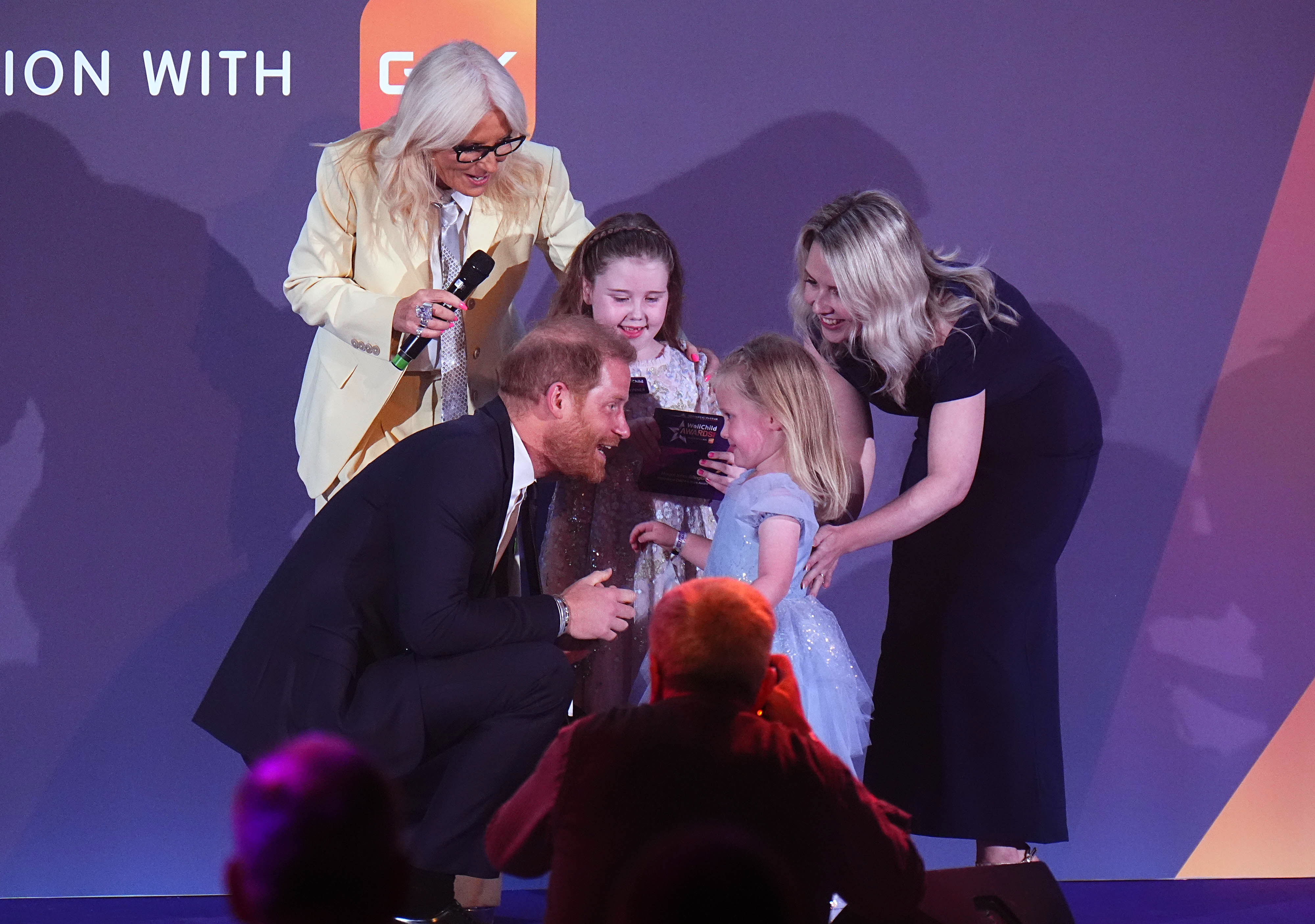 Britain's Prince Harry speaks to Margot Jones-Billington's sister Adeleigh during the WellChild Awards 2026, which celebrates the achievements and resilience of seriously ill youngsters and their families, in London, Monday, Sept. 21, 2026. (Aaron Chown/Pool Photo via AP)