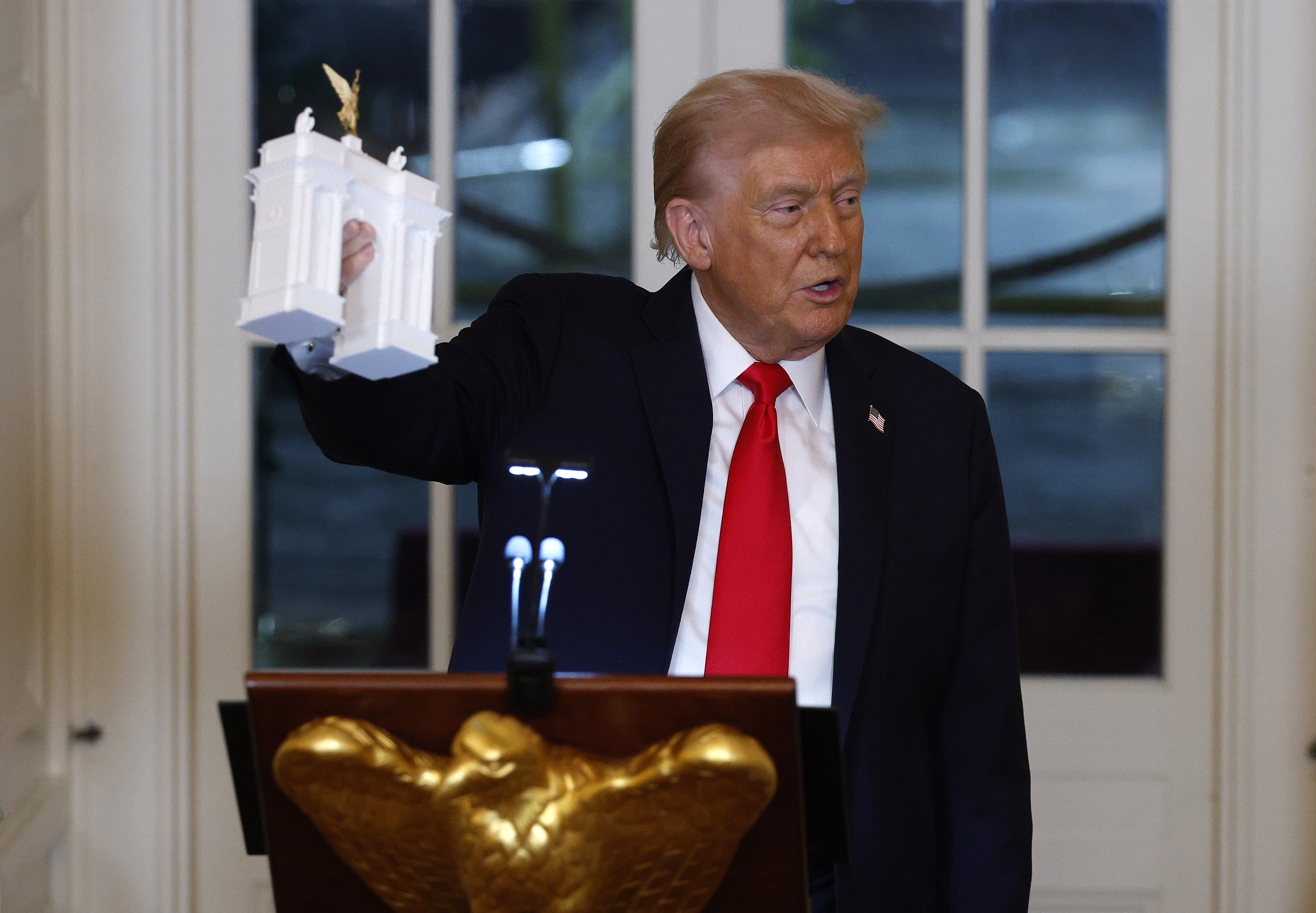 WASHINGTON, DC - OCTOBER 15: U.S. President Donald Trump holds models of an arch as he delivers remarks during a ballroom fundraising dinner in the East Room of the White House on October 15, 2025 in Washington, DC. Trump hosted organizations and individuals for a fundraising dinner for the new $250 million ballroom addition currently under construction at the White House. (Photo by Kevin Dietsch/Getty Images)