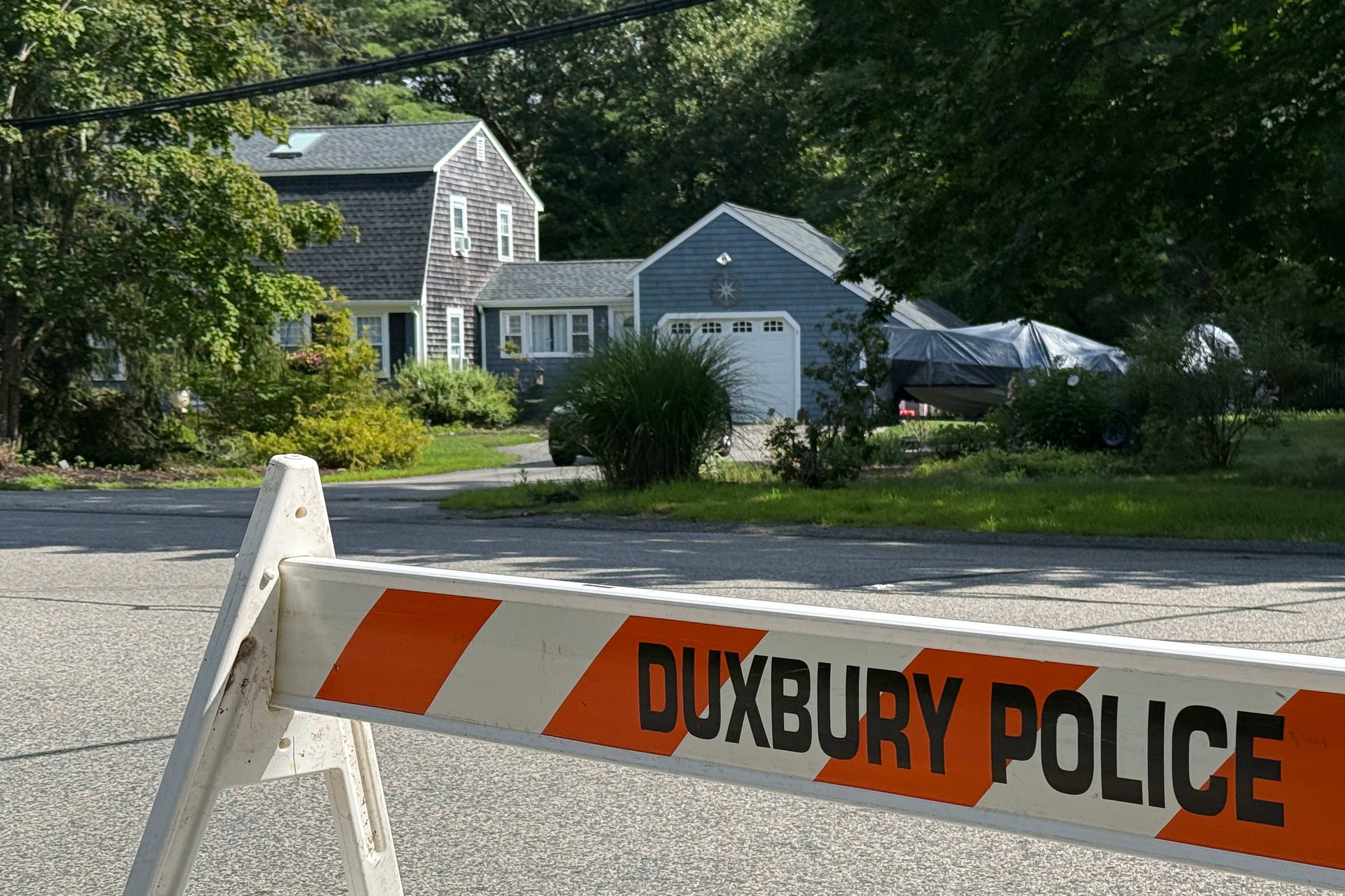 A police barricade stands outside the former home of Lindsay Clancy in Duxbury, Mass., on Friday, July 31, 2026. (AP Photo/Rodrique Ngowi)